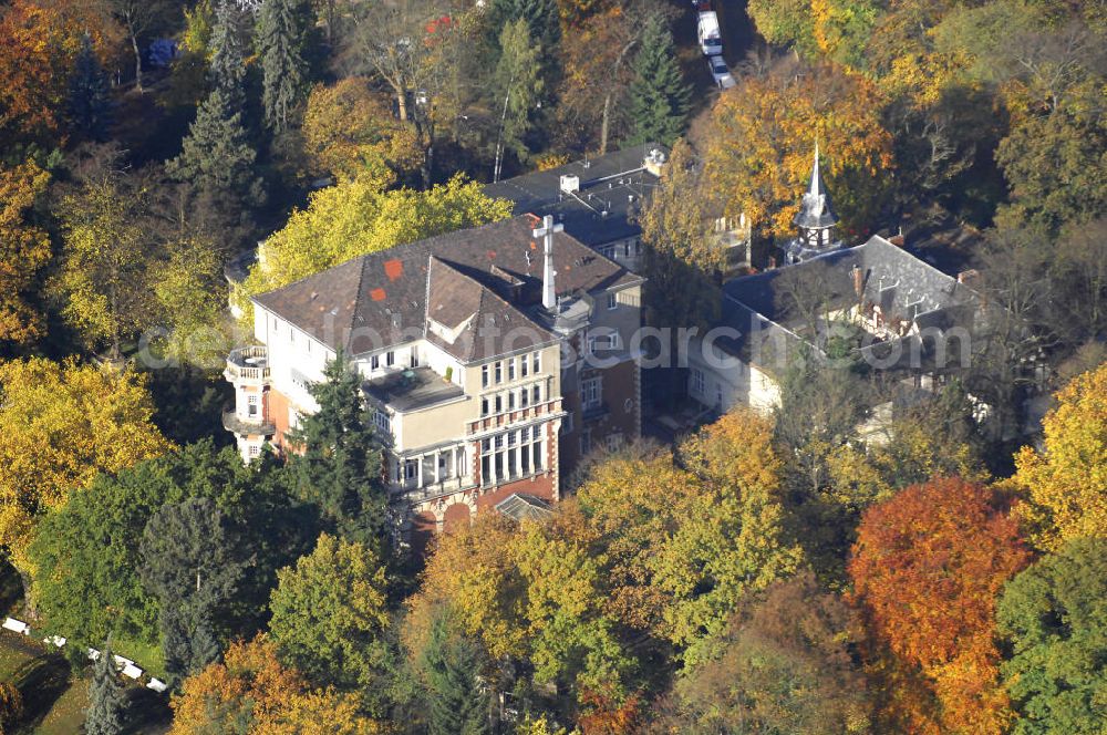 Aerial photograph Berlin - Blick auf den uferbereich an der Villa Siemens Am Kleinen Wannsee direkt gegenüber des Neubaus zum Immanuel-Krankenhauses in Berlin-Wannsee. Das Krankenhaus gehört zur Immanuel Diakonie Group (IDG), die eine Einrichtung der Evangelisch-Freikirchlichen Gemeinde Berlin-Schöneberg ist. Die Verwaltung der IDG hatte ihren Sitz in der Villa Siemens. Das Gebäude war einst eine Sommerresidenz von Arnold von Siemens, dem ältesten Sohn des Firmengründers Werner von Siemens. Die Architekten waren Paul und Walther Hentschel, 1888 wurde der Bau fertiggestellt. Die Villa Siemens gehörte zur Colonie Alsen, einer Siedlung für das Berliner Großbürgertum, die Wilhelm Conrad 1863 gegründet hatte. Nach dem Zweiten Weltkrieg stifteten Hermann und Charlotte von Siemens die Villa der Baptisten-Gemeinde mit der Auflage, sie für soziale Zwecke zu nutzen. Es ist das einzige Ensemble von Gebäude und Park der ehemaligen Kolonie, das bis heute erhalten geblieben ist. Der Krankenhausbetrieb ist jetzt in einem Neubau auf der gegenüberliegenden Straßenseite untergebracht. Das ehemals zum Areal gehörende Anwesen Am kleinen Wannsee Nr 4 wurde verkauft. ISA Immobilien Service Agentur GmbH, Herr Roland Kober