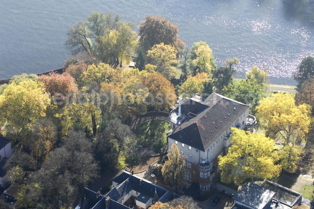 Aerial photograph Berlin - Blick auf den uferbereich an der Villa Siemens Am Kleinen Wannsee direkt gegenüber des Neubaus zum Immanuel-Krankenhauses in Berlin-Wannsee. Das Krankenhaus gehört zur Immanuel Diakonie Group (IDG), die eine Einrichtung der Evangelisch-Freikirchlichen Gemeinde Berlin-Schöneberg ist. Die Verwaltung der IDG hatte ihren Sitz in der Villa Siemens. Das Gebäude war einst eine Sommerresidenz von Arnold von Siemens, dem ältesten Sohn des Firmengründers Werner von Siemens. Die Architekten waren Paul und Walther Hentschel, 1888 wurde der Bau fertiggestellt. Die Villa Siemens gehörte zur Colonie Alsen, einer Siedlung für das Berliner Großbürgertum, die Wilhelm Conrad 1863 gegründet hatte. Nach dem Zweiten Weltkrieg stifteten Hermann und Charlotte von Siemens die Villa der Baptisten-Gemeinde mit der Auflage, sie für soziale Zwecke zu nutzen. Es ist das einzige Ensemble von Gebäude und Park der ehemaligen Kolonie, das bis heute erhalten geblieben ist. Der Krankenhausbetrieb ist jetzt in einem Neubau auf der gegenüberliegenden Straßenseite untergebracht. Das ehemals zum Areal gehörende Anwesen Am kleinen Wannsee Nr 4 wurde verkauft. ISA Immobilien Service Agentur GmbH, Herr Roland Kober