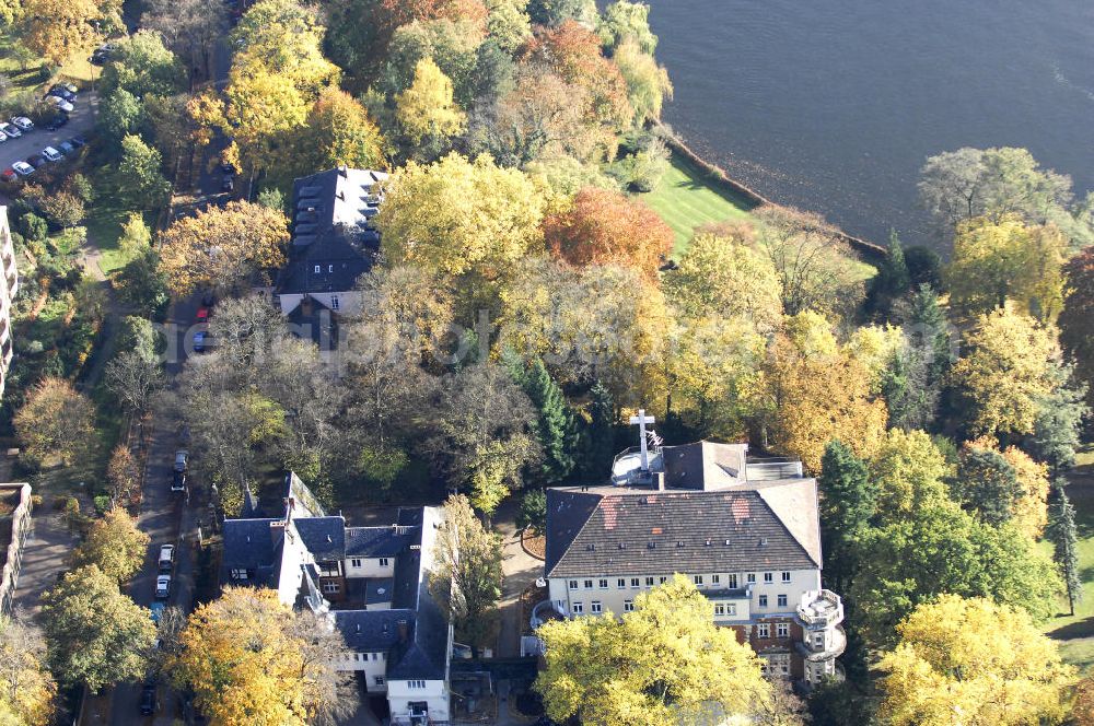 Aerial image Berlin - Blick auf den uferbereich an der Villa Siemens Am Kleinen Wannsee direkt gegenüber des Neubaus zum Immanuel-Krankenhauses in Berlin-Wannsee. Das Krankenhaus gehört zur Immanuel Diakonie Group (IDG), die eine Einrichtung der Evangelisch-Freikirchlichen Gemeinde Berlin-Schöneberg ist. Die Verwaltung der IDG hatte ihren Sitz in der Villa Siemens. Das Gebäude war einst eine Sommerresidenz von Arnold von Siemens, dem ältesten Sohn des Firmengründers Werner von Siemens. Die Architekten waren Paul und Walther Hentschel, 1888 wurde der Bau fertiggestellt. Die Villa Siemens gehörte zur Colonie Alsen, einer Siedlung für das Berliner Großbürgertum, die Wilhelm Conrad 1863 gegründet hatte. Nach dem Zweiten Weltkrieg stifteten Hermann und Charlotte von Siemens die Villa der Baptisten-Gemeinde mit der Auflage, sie für soziale Zwecke zu nutzen. Es ist das einzige Ensemble von Gebäude und Park der ehemaligen Kolonie, das bis heute erhalten geblieben ist. Der Krankenhausbetrieb ist jetzt in einem Neubau auf der gegenüberliegenden Straßenseite untergebracht. Das ehemals zum Areal gehörende Anwesen Am kleinen Wannsee Nr 4 wurde verkauft. ISA Immobilien Service Agentur GmbH, Herr Roland Kober