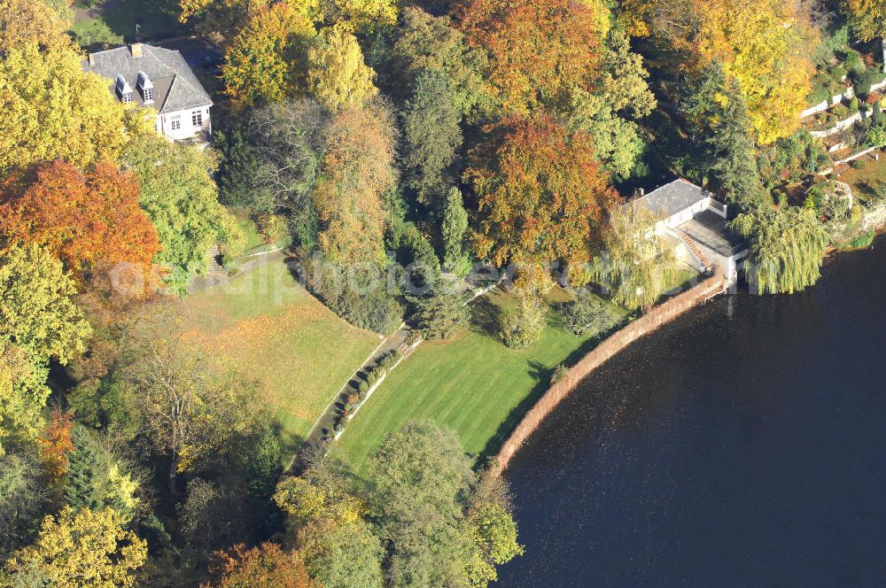 Berlin from the bird's eye view: Blick auf den uferbereich an der Villa Siemens Am Kleinen Wannsee direkt gegenüber des Neubaus zum Immanuel-Krankenhauses in Berlin-Wannsee. Das Krankenhaus gehört zur Immanuel Diakonie Group (IDG), die eine Einrichtung der Evangelisch-Freikirchlichen Gemeinde Berlin-Schöneberg ist. Die Verwaltung der IDG hatte ihren Sitz in der Villa Siemens. Das Gebäude war einst eine Sommerresidenz von Arnold von Siemens, dem ältesten Sohn des Firmengründers Werner von Siemens. Die Architekten waren Paul und Walther Hentschel, 1888 wurde der Bau fertiggestellt. Die Villa Siemens gehörte zur Colonie Alsen, einer Siedlung für das Berliner Großbürgertum, die Wilhelm Conrad 1863 gegründet hatte. Nach dem Zweiten Weltkrieg stifteten Hermann und Charlotte von Siemens die Villa der Baptisten-Gemeinde mit der Auflage, sie für soziale Zwecke zu nutzen. Es ist das einzige Ensemble von Gebäude und Park der ehemaligen Kolonie, das bis heute erhalten geblieben ist. Der Krankenhausbetrieb ist jetzt in einem Neubau auf der gegenüberliegenden Straßenseite untergebracht. Das ehemals zum Areal gehörende Anwesen Am kleinen Wannsee Nr 4 wurde verkauft. ISA Immobilien Service Agentur GmbH, Herr Roland Kober