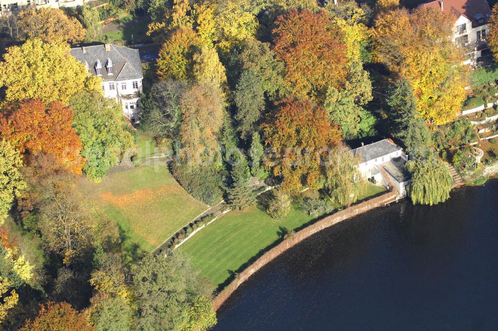 Aerial image Berlin - Blick auf den uferbereich an der Villa Siemens Am Kleinen Wannsee direkt gegenüber des Neubaus zum Immanuel-Krankenhauses in Berlin-Wannsee. Das Krankenhaus gehört zur Immanuel Diakonie Group (IDG), die eine Einrichtung der Evangelisch-Freikirchlichen Gemeinde Berlin-Schöneberg ist. Die Verwaltung der IDG hatte ihren Sitz in der Villa Siemens. Das Gebäude war einst eine Sommerresidenz von Arnold von Siemens, dem ältesten Sohn des Firmengründers Werner von Siemens. Die Architekten waren Paul und Walther Hentschel, 1888 wurde der Bau fertiggestellt. Die Villa Siemens gehörte zur Colonie Alsen, einer Siedlung für das Berliner Großbürgertum, die Wilhelm Conrad 1863 gegründet hatte. Nach dem Zweiten Weltkrieg stifteten Hermann und Charlotte von Siemens die Villa der Baptisten-Gemeinde mit der Auflage, sie für soziale Zwecke zu nutzen. Es ist das einzige Ensemble von Gebäude und Park der ehemaligen Kolonie, das bis heute erhalten geblieben ist. Der Krankenhausbetrieb ist jetzt in einem Neubau auf der gegenüberliegenden Straßenseite untergebracht. Das ehemals zum Areal gehörende Anwesen Am kleinen Wannsee Nr 4 wurde verkauft. ISA Immobilien Service Agentur GmbH, Herr Roland Kober