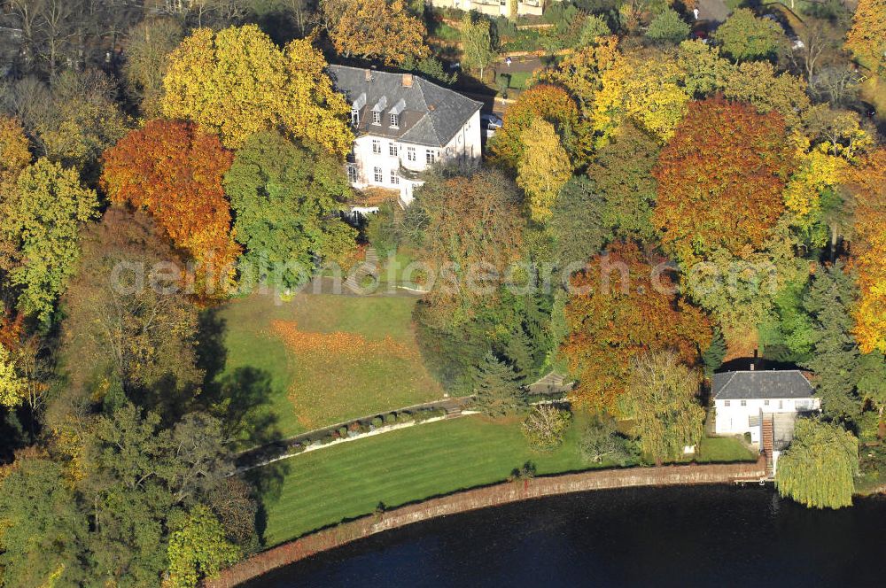 Berlin from above - Blick auf den uferbereich an der Villa Siemens Am Kleinen Wannsee direkt gegenüber des Neubaus zum Immanuel-Krankenhauses in Berlin-Wannsee. Das Krankenhaus gehört zur Immanuel Diakonie Group (IDG), die eine Einrichtung der Evangelisch-Freikirchlichen Gemeinde Berlin-Schöneberg ist. Die Verwaltung der IDG hatte ihren Sitz in der Villa Siemens. Das Gebäude war einst eine Sommerresidenz von Arnold von Siemens, dem ältesten Sohn des Firmengründers Werner von Siemens. Die Architekten waren Paul und Walther Hentschel, 1888 wurde der Bau fertiggestellt. Die Villa Siemens gehörte zur Colonie Alsen, einer Siedlung für das Berliner Großbürgertum, die Wilhelm Conrad 1863 gegründet hatte. Nach dem Zweiten Weltkrieg stifteten Hermann und Charlotte von Siemens die Villa der Baptisten-Gemeinde mit der Auflage, sie für soziale Zwecke zu nutzen. Es ist das einzige Ensemble von Gebäude und Park der ehemaligen Kolonie, das bis heute erhalten geblieben ist. Der Krankenhausbetrieb ist jetzt in einem Neubau auf der gegenüberliegenden Straßenseite untergebracht. Das ehemals zum Areal gehörende Anwesen Am kleinen Wannsee Nr 4 wurde verkauft. ISA Immobilien Service Agentur GmbH, Herr Roland Kober