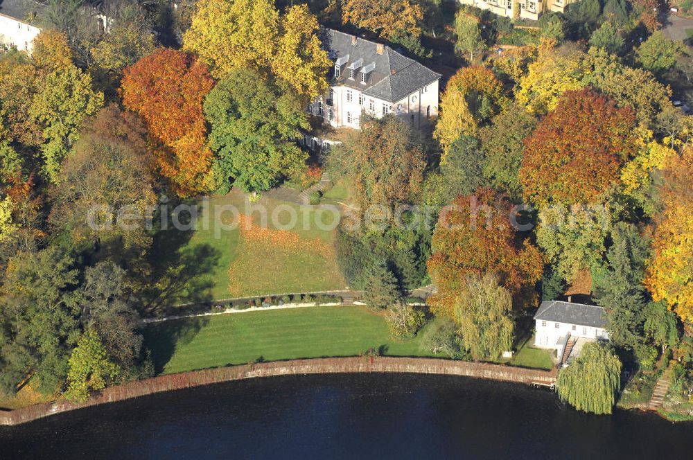 Berlin from the bird's eye view: Blick auf den uferbereich an der Villa Siemens Am Kleinen Wannsee direkt gegenüber des Neubaus zum Immanuel-Krankenhauses in Berlin-Wannsee. Das Krankenhaus gehört zur Immanuel Diakonie Group (IDG), die eine Einrichtung der Evangelisch-Freikirchlichen Gemeinde Berlin-Schöneberg ist. Die Verwaltung der IDG hatte ihren Sitz in der Villa Siemens. Das Gebäude war einst eine Sommerresidenz von Arnold von Siemens, dem ältesten Sohn des Firmengründers Werner von Siemens. Die Architekten waren Paul und Walther Hentschel, 1888 wurde der Bau fertiggestellt. Die Villa Siemens gehörte zur Colonie Alsen, einer Siedlung für das Berliner Großbürgertum, die Wilhelm Conrad 1863 gegründet hatte. Nach dem Zweiten Weltkrieg stifteten Hermann und Charlotte von Siemens die Villa der Baptisten-Gemeinde mit der Auflage, sie für soziale Zwecke zu nutzen. Es ist das einzige Ensemble von Gebäude und Park der ehemaligen Kolonie, das bis heute erhalten geblieben ist. Der Krankenhausbetrieb ist jetzt in einem Neubau auf der gegenüberliegenden Straßenseite untergebracht. Das ehemals zum Areal gehörende Anwesen Am kleinen Wannsee Nr 4 wurde verkauft. ISA Immobilien Service Agentur GmbH, Herr Roland Kober