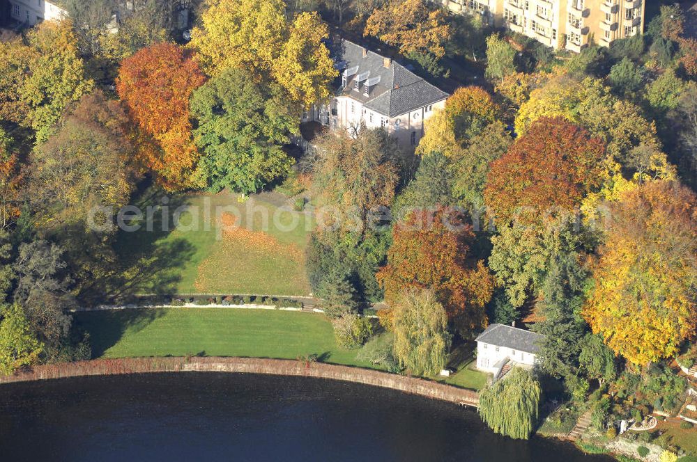 Aerial image Berlin - Blick auf den uferbereich an der Villa Siemens Am Kleinen Wannsee direkt gegenüber des Neubaus zum Immanuel-Krankenhauses in Berlin-Wannsee. Das Krankenhaus gehört zur Immanuel Diakonie Group (IDG), die eine Einrichtung der Evangelisch-Freikirchlichen Gemeinde Berlin-Schöneberg ist. Die Verwaltung der IDG hatte ihren Sitz in der Villa Siemens. Das Gebäude war einst eine Sommerresidenz von Arnold von Siemens, dem ältesten Sohn des Firmengründers Werner von Siemens. Die Architekten waren Paul und Walther Hentschel, 1888 wurde der Bau fertiggestellt. Die Villa Siemens gehörte zur Colonie Alsen, einer Siedlung für das Berliner Großbürgertum, die Wilhelm Conrad 1863 gegründet hatte. Nach dem Zweiten Weltkrieg stifteten Hermann und Charlotte von Siemens die Villa der Baptisten-Gemeinde mit der Auflage, sie für soziale Zwecke zu nutzen. Es ist das einzige Ensemble von Gebäude und Park der ehemaligen Kolonie, das bis heute erhalten geblieben ist. Der Krankenhausbetrieb ist jetzt in einem Neubau auf der gegenüberliegenden Straßenseite untergebracht. Das ehemals zum Areal gehörende Anwesen Am kleinen Wannsee Nr 4 wurde verkauft. ISA Immobilien Service Agentur GmbH, Herr Roland Kober