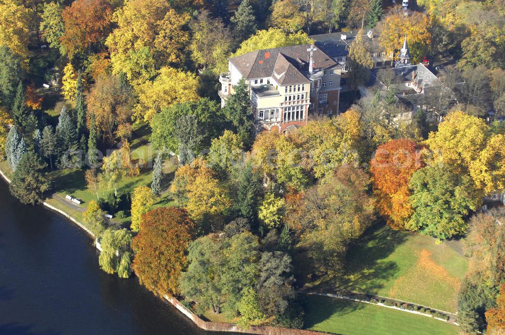 Aerial image Berlin - Blick auf den uferbereich an der Villa Siemens Am Kleinen Wannsee direkt gegenüber des Neubaus zum Immanuel-Krankenhauses in Berlin-Wannsee. Das Krankenhaus gehört zur Immanuel Diakonie Group (IDG), die eine Einrichtung der Evangelisch-Freikirchlichen Gemeinde Berlin-Schöneberg ist. Die Verwaltung der IDG hatte ihren Sitz in der Villa Siemens. Das Gebäude war einst eine Sommerresidenz von Arnold von Siemens, dem ältesten Sohn des Firmengründers Werner von Siemens. Die Architekten waren Paul und Walther Hentschel, 1888 wurde der Bau fertiggestellt. Die Villa Siemens gehörte zur Colonie Alsen, einer Siedlung für das Berliner Großbürgertum, die Wilhelm Conrad 1863 gegründet hatte. Nach dem Zweiten Weltkrieg stifteten Hermann und Charlotte von Siemens die Villa der Baptisten-Gemeinde mit der Auflage, sie für soziale Zwecke zu nutzen. Es ist das einzige Ensemble von Gebäude und Park der ehemaligen Kolonie, das bis heute erhalten geblieben ist. Der Krankenhausbetrieb ist jetzt in einem Neubau auf der gegenüberliegenden Straßenseite untergebracht. Das ehemals zum Areal gehörende Anwesen Am kleinen Wannsee Nr 4 wurde verkauft. ISA Immobilien Service Agentur GmbH, Herr Roland Kober