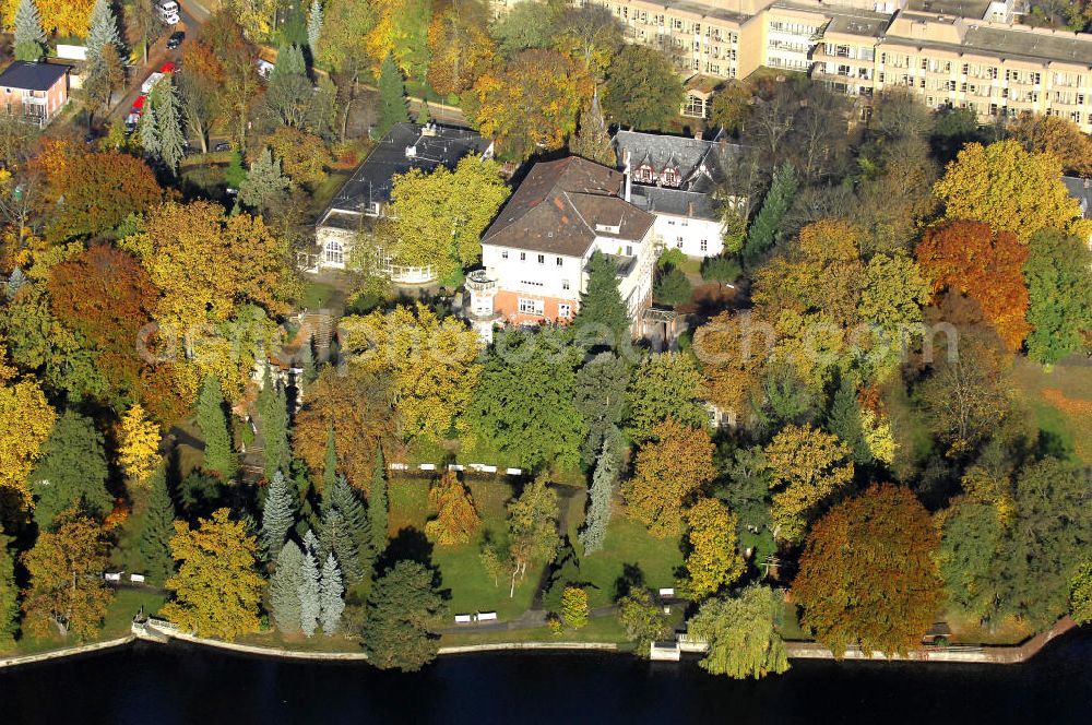 Aerial photograph Berlin - Blick auf den uferbereich an der Villa Siemens Am Kleinen Wannsee direkt gegenüber des Neubaus zum Immanuel-Krankenhauses in Berlin-Wannsee. Das Krankenhaus gehört zur Immanuel Diakonie Group (IDG), die eine Einrichtung der Evangelisch-Freikirchlichen Gemeinde Berlin-Schöneberg ist. Die Verwaltung der IDG hatte ihren Sitz in der Villa Siemens. Das Gebäude war einst eine Sommerresidenz von Arnold von Siemens, dem ältesten Sohn des Firmengründers Werner von Siemens. Die Architekten waren Paul und Walther Hentschel, 1888 wurde der Bau fertiggestellt. Die Villa Siemens gehörte zur Colonie Alsen, einer Siedlung für das Berliner Großbürgertum, die Wilhelm Conrad 1863 gegründet hatte. Nach dem Zweiten Weltkrieg stifteten Hermann und Charlotte von Siemens die Villa der Baptisten-Gemeinde mit der Auflage, sie für soziale Zwecke zu nutzen. Es ist das einzige Ensemble von Gebäude und Park der ehemaligen Kolonie, das bis heute erhalten geblieben ist. Der Krankenhausbetrieb ist jetzt in einem Neubau auf der gegenüberliegenden Straßenseite untergebracht. Das ehemals zum Areal gehörende Anwesen Am kleinen Wannsee Nr 4 wurde verkauft. ISA Immobilien Service Agentur GmbH, Herr Roland Kober