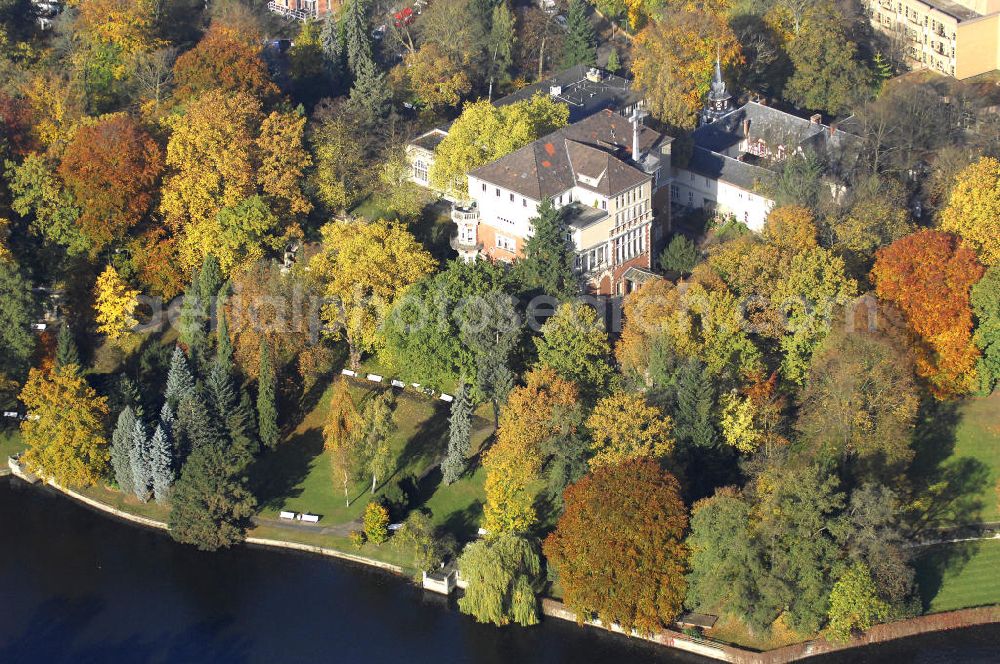 Aerial image Berlin - Blick auf den uferbereich an der Villa Siemens Am Kleinen Wannsee direkt gegenüber des Neubaus zum Immanuel-Krankenhauses in Berlin-Wannsee. Das Krankenhaus gehört zur Immanuel Diakonie Group (IDG), die eine Einrichtung der Evangelisch-Freikirchlichen Gemeinde Berlin-Schöneberg ist. Die Verwaltung der IDG hatte ihren Sitz in der Villa Siemens. Das Gebäude war einst eine Sommerresidenz von Arnold von Siemens, dem ältesten Sohn des Firmengründers Werner von Siemens. Die Architekten waren Paul und Walther Hentschel, 1888 wurde der Bau fertiggestellt. Die Villa Siemens gehörte zur Colonie Alsen, einer Siedlung für das Berliner Großbürgertum, die Wilhelm Conrad 1863 gegründet hatte. Nach dem Zweiten Weltkrieg stifteten Hermann und Charlotte von Siemens die Villa der Baptisten-Gemeinde mit der Auflage, sie für soziale Zwecke zu nutzen. Es ist das einzige Ensemble von Gebäude und Park der ehemaligen Kolonie, das bis heute erhalten geblieben ist. Der Krankenhausbetrieb ist jetzt in einem Neubau auf der gegenüberliegenden Straßenseite untergebracht. Das ehemals zum Areal gehörende Anwesen Am kleinen Wannsee Nr 4 wurde verkauft. ISA Immobilien Service Agentur GmbH, Herr Roland Kober