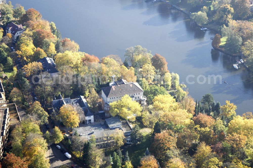 Berlin from the bird's eye view: Blick auf den uferbereich an der Villa Siemens Am Kleinen Wannsee direkt gegenüber des Neubaus zum Immanuel-Krankenhauses in Berlin-Wannsee. Das Krankenhaus gehört zur Immanuel Diakonie Group (IDG), die eine Einrichtung der Evangelisch-Freikirchlichen Gemeinde Berlin-Schöneberg ist. Die Verwaltung der IDG hatte ihren Sitz in der Villa Siemens. Das Gebäude war einst eine Sommerresidenz von Arnold von Siemens, dem ältesten Sohn des Firmengründers Werner von Siemens. Die Architekten waren Paul und Walther Hentschel, 1888 wurde der Bau fertiggestellt. Die Villa Siemens gehörte zur Colonie Alsen, einer Siedlung für das Berliner Großbürgertum, die Wilhelm Conrad 1863 gegründet hatte. Nach dem Zweiten Weltkrieg stifteten Hermann und Charlotte von Siemens die Villa der Baptisten-Gemeinde mit der Auflage, sie für soziale Zwecke zu nutzen. Es ist das einzige Ensemble von Gebäude und Park der ehemaligen Kolonie, das bis heute erhalten geblieben ist. Der Krankenhausbetrieb ist jetzt in einem Neubau auf der gegenüberliegenden Straßenseite untergebracht. Das ehemals zum Areal gehörende Anwesen Am kleinen Wannsee Nr 4 wurde verkauft. ISA Immobilien Service Agentur GmbH, Herr Roland Kober