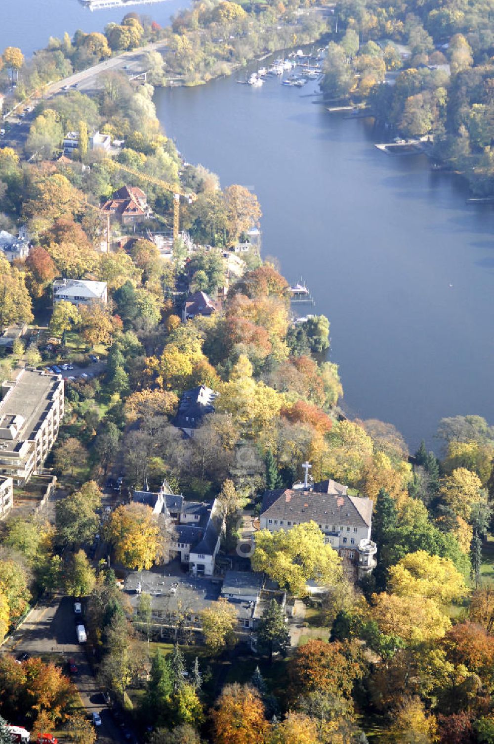 Aerial image Berlin - Blick auf den uferbereich an der Villa Siemens Am Kleinen Wannsee direkt gegenüber des Neubaus zum Immanuel-Krankenhauses in Berlin-Wannsee. Das Krankenhaus gehört zur Immanuel Diakonie Group (IDG), die eine Einrichtung der Evangelisch-Freikirchlichen Gemeinde Berlin-Schöneberg ist. Die Verwaltung der IDG hatte ihren Sitz in der Villa Siemens. Das Gebäude war einst eine Sommerresidenz von Arnold von Siemens, dem ältesten Sohn des Firmengründers Werner von Siemens. Die Architekten waren Paul und Walther Hentschel, 1888 wurde der Bau fertiggestellt. Die Villa Siemens gehörte zur Colonie Alsen, einer Siedlung für das Berliner Großbürgertum, die Wilhelm Conrad 1863 gegründet hatte. Nach dem Zweiten Weltkrieg stifteten Hermann und Charlotte von Siemens die Villa der Baptisten-Gemeinde mit der Auflage, sie für soziale Zwecke zu nutzen. Es ist das einzige Ensemble von Gebäude und Park der ehemaligen Kolonie, das bis heute erhalten geblieben ist. Der Krankenhausbetrieb ist jetzt in einem Neubau auf der gegenüberliegenden Straßenseite untergebracht. Das ehemals zum Areal gehörende Anwesen Am kleinen Wannsee Nr 4 wurde verkauft. ISA Immobilien Service Agentur GmbH, Herr Roland Kober