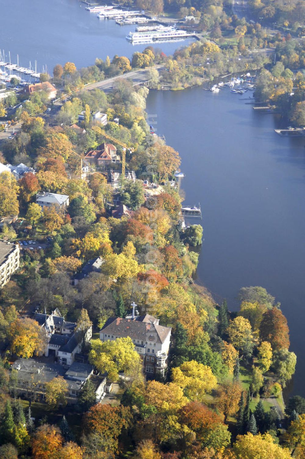 Aerial photograph Berlin - Blick auf den uferbereich an der Villa Siemens Am Kleinen Wannsee direkt gegenüber des Neubaus zum Immanuel-Krankenhauses in Berlin-Wannsee. Das Krankenhaus gehört zur Immanuel Diakonie Group (IDG), die eine Einrichtung der Evangelisch-Freikirchlichen Gemeinde Berlin-Schöneberg ist. Die Verwaltung der IDG hatte ihren Sitz in der Villa Siemens. Das Gebäude war einst eine Sommerresidenz von Arnold von Siemens, dem ältesten Sohn des Firmengründers Werner von Siemens. Die Architekten waren Paul und Walther Hentschel, 1888 wurde der Bau fertiggestellt. Die Villa Siemens gehörte zur Colonie Alsen, einer Siedlung für das Berliner Großbürgertum, die Wilhelm Conrad 1863 gegründet hatte. Nach dem Zweiten Weltkrieg stifteten Hermann und Charlotte von Siemens die Villa der Baptisten-Gemeinde mit der Auflage, sie für soziale Zwecke zu nutzen. Es ist das einzige Ensemble von Gebäude und Park der ehemaligen Kolonie, das bis heute erhalten geblieben ist. Der Krankenhausbetrieb ist jetzt in einem Neubau auf der gegenüberliegenden Straßenseite untergebracht. Das ehemals zum Areal gehörende Anwesen Am kleinen Wannsee Nr 4 wurde verkauft. ISA Immobilien Service Agentur GmbH, Herr Roland Kober