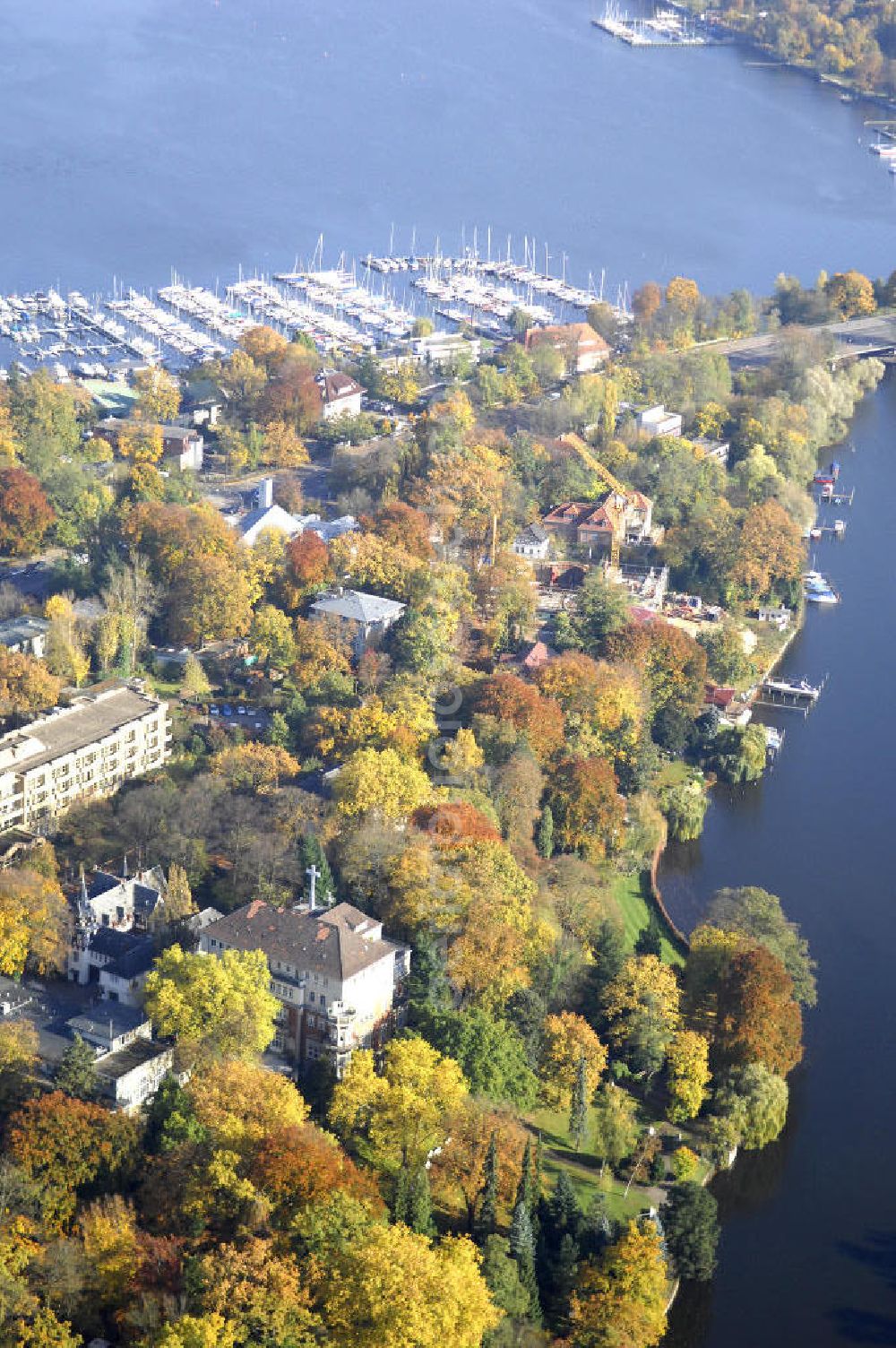 Berlin from the bird's eye view: Blick auf den uferbereich an der Villa Siemens Am Kleinen Wannsee direkt gegenüber des Neubaus zum Immanuel-Krankenhauses in Berlin-Wannsee. Das Krankenhaus gehört zur Immanuel Diakonie Group (IDG), die eine Einrichtung der Evangelisch-Freikirchlichen Gemeinde Berlin-Schöneberg ist. Die Verwaltung der IDG hatte ihren Sitz in der Villa Siemens. Das Gebäude war einst eine Sommerresidenz von Arnold von Siemens, dem ältesten Sohn des Firmengründers Werner von Siemens. Die Architekten waren Paul und Walther Hentschel, 1888 wurde der Bau fertiggestellt. Die Villa Siemens gehörte zur Colonie Alsen, einer Siedlung für das Berliner Großbürgertum, die Wilhelm Conrad 1863 gegründet hatte. Nach dem Zweiten Weltkrieg stifteten Hermann und Charlotte von Siemens die Villa der Baptisten-Gemeinde mit der Auflage, sie für soziale Zwecke zu nutzen. Es ist das einzige Ensemble von Gebäude und Park der ehemaligen Kolonie, das bis heute erhalten geblieben ist. Der Krankenhausbetrieb ist jetzt in einem Neubau auf der gegenüberliegenden Straßenseite untergebracht. Das ehemals zum Areal gehörende Anwesen Am kleinen Wannsee Nr 4 wurde verkauft. ISA Immobilien Service Agentur GmbH, Herr Roland Kober