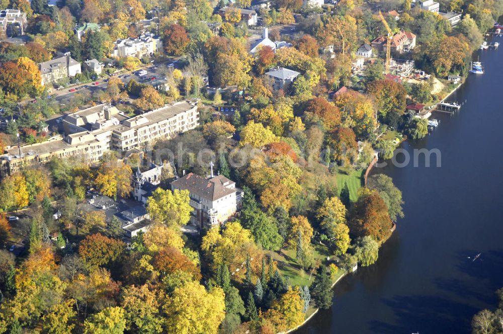 Aerial image Berlin - Blick auf den uferbereich an der Villa Siemens Am Kleinen Wannsee direkt gegenüber des Neubaus zum Immanuel-Krankenhauses in Berlin-Wannsee. Das Krankenhaus gehört zur Immanuel Diakonie Group (IDG), die eine Einrichtung der Evangelisch-Freikirchlichen Gemeinde Berlin-Schöneberg ist. Die Verwaltung der IDG hatte ihren Sitz in der Villa Siemens. Das Gebäude war einst eine Sommerresidenz von Arnold von Siemens, dem ältesten Sohn des Firmengründers Werner von Siemens. Die Architekten waren Paul und Walther Hentschel, 1888 wurde der Bau fertiggestellt. Die Villa Siemens gehörte zur Colonie Alsen, einer Siedlung für das Berliner Großbürgertum, die Wilhelm Conrad 1863 gegründet hatte. Nach dem Zweiten Weltkrieg stifteten Hermann und Charlotte von Siemens die Villa der Baptisten-Gemeinde mit der Auflage, sie für soziale Zwecke zu nutzen. Es ist das einzige Ensemble von Gebäude und Park der ehemaligen Kolonie, das bis heute erhalten geblieben ist. Der Krankenhausbetrieb ist jetzt in einem Neubau auf der gegenüberliegenden Straßenseite untergebracht. Das ehemals zum Areal gehörende Anwesen Am kleinen Wannsee Nr 4 wurde verkauft. ISA Immobilien Service Agentur GmbH, Herr Roland Kober