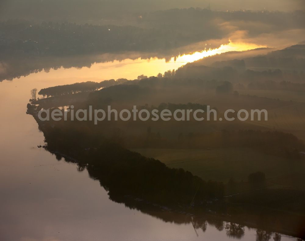 Essen from the bird's eye view: Autumn weather with fog and mist in the sunset at the shore areas in the sea area of the Baldeneysee in Essen in North Rhine-Westphalia