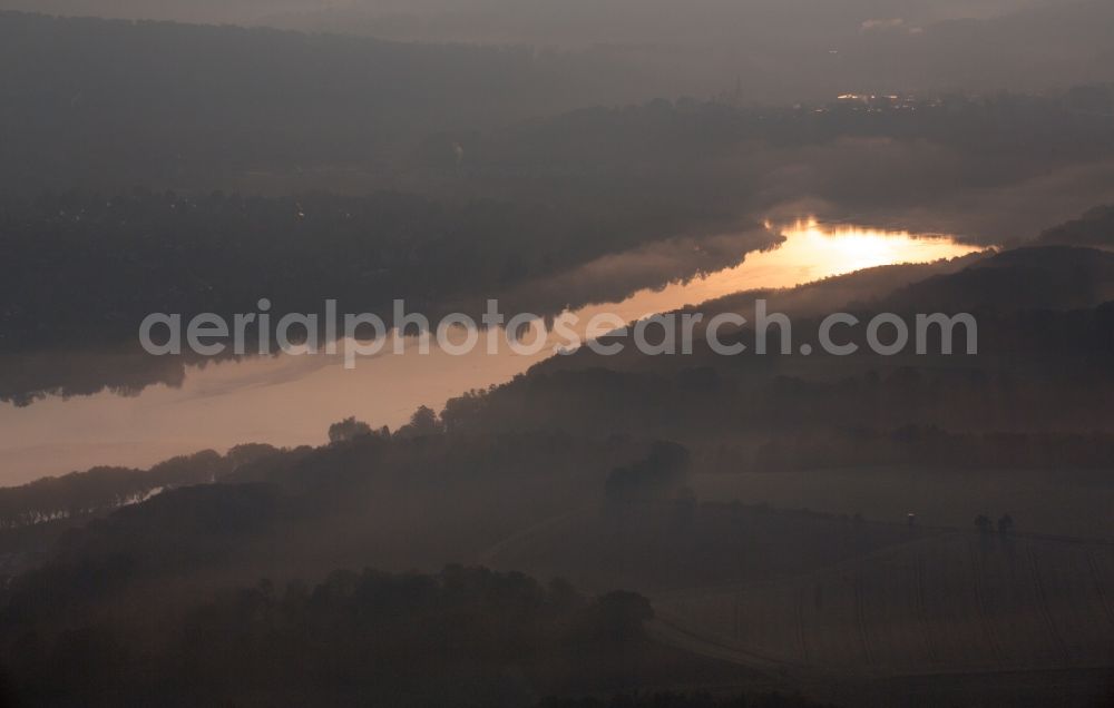 Essen from the bird's eye view: Autumn weather with fog and mist in the sunset at the shore areas in the sea area of the Baldeneysee in Essen in North Rhine-Westphalia