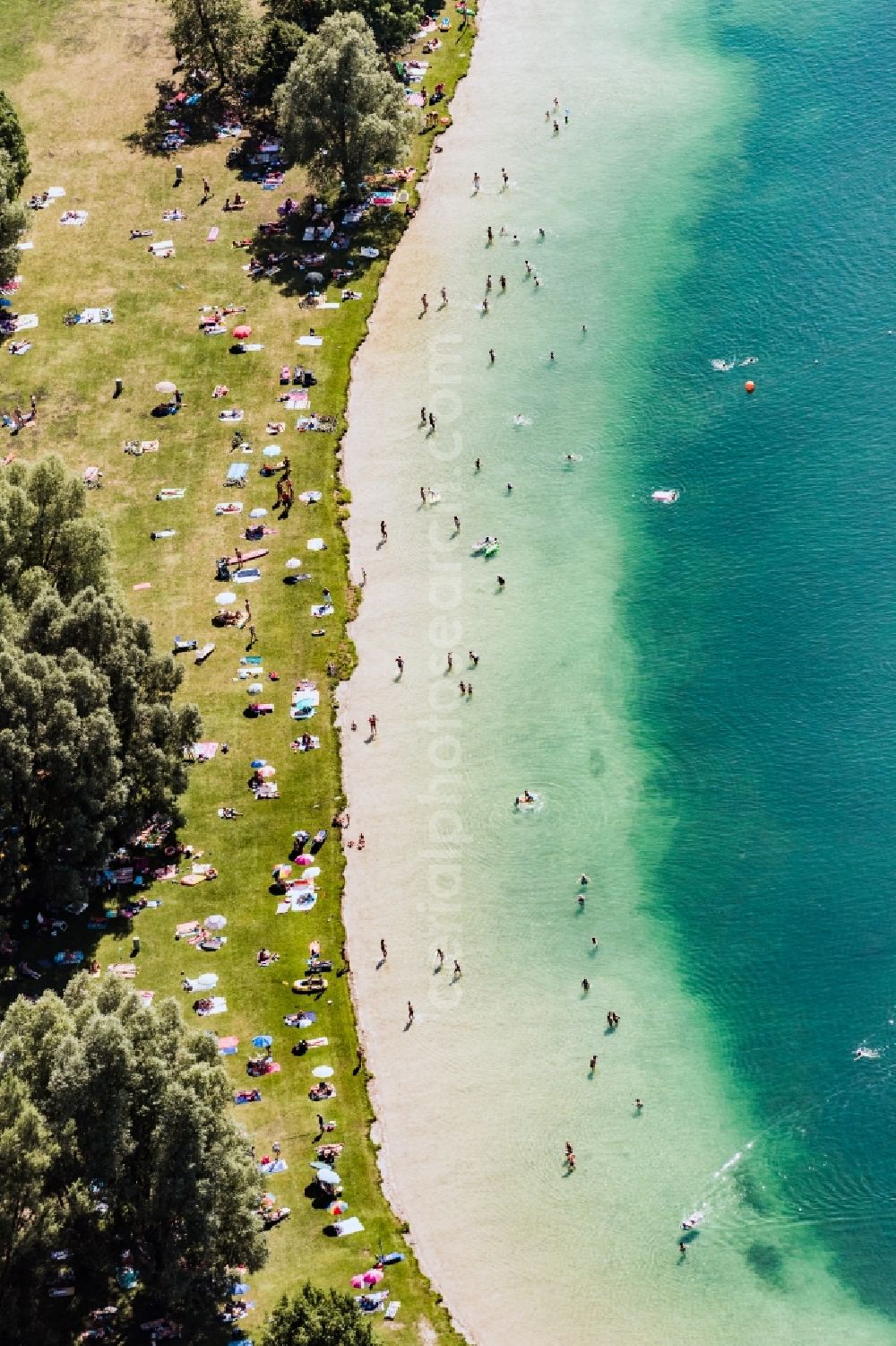 Unterföhring from the bird's eye view: Riparian areas on the lake area of Feringasee mit Besuchern der Liegewiesen in Unterfoehring in the state Bavaria