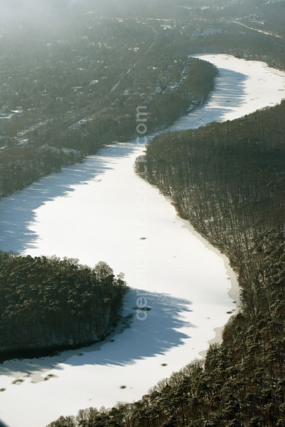 Berlin from the bird's eye view: Riparian areas on the lake area of Schlachtensee with wintry snowy ice in Berlin in Germany