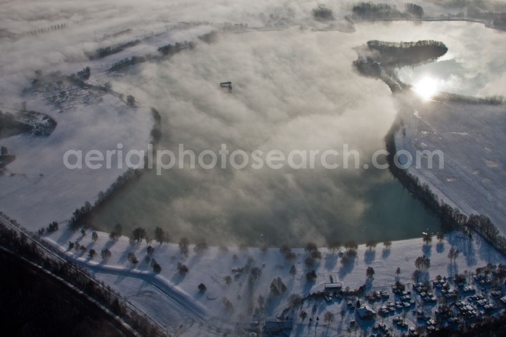 Lauterbourg from the bird's eye view: Riparian areas on the lake area of wintry snowy Bassin des Mouettes in Lauterbourg in Grand Est, France