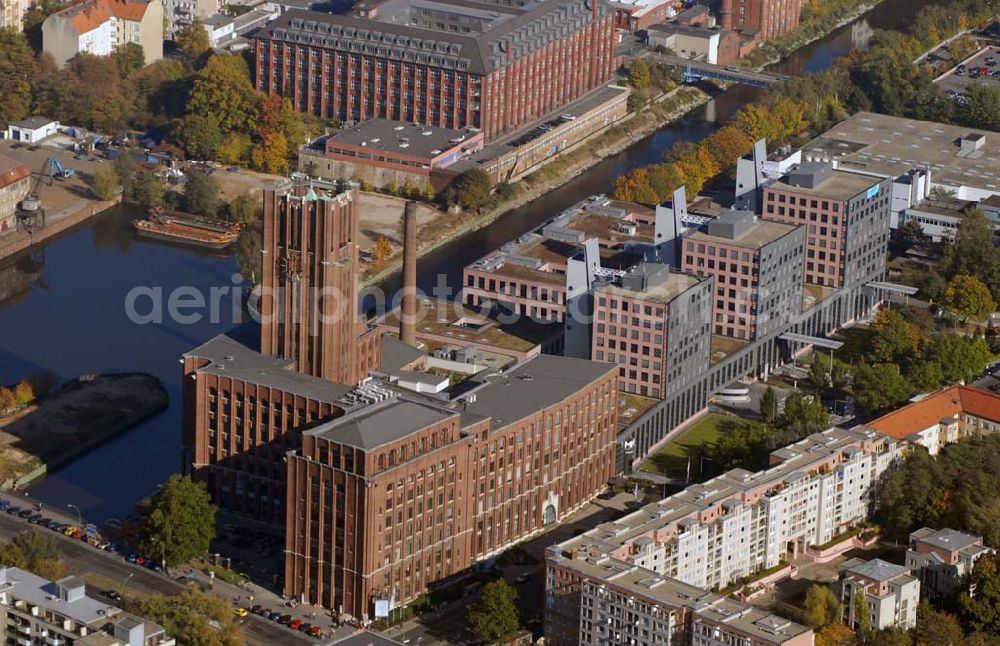 Aerial photograph Berlin-Mariendorf - Blick auf das Ullsteinhaus am Mariendorfer Damm in Mariendorf. Es liegt direkt am Teltowkanal neben der U-Bahnlinie U6. Das Ullsteinhaus wurde 1925-27 vom Architekten Prof. Eugen Schmol für den Ullstein-Verlag gebaut, der anschließend in dem Gebäude residierte. Heute beherbergt das Ullsteinhaus viele Geschäfte und Büros, dazu gehören u.a.: das Systemhaus Computacenter, die SCHUFA Holding AG, vers. medizinische Einrichtungen, die WBS Training AG Bildungspartner der SAP AG. Im Keller des Ullsteinhauses ist heute die Amber Suite zu finden.