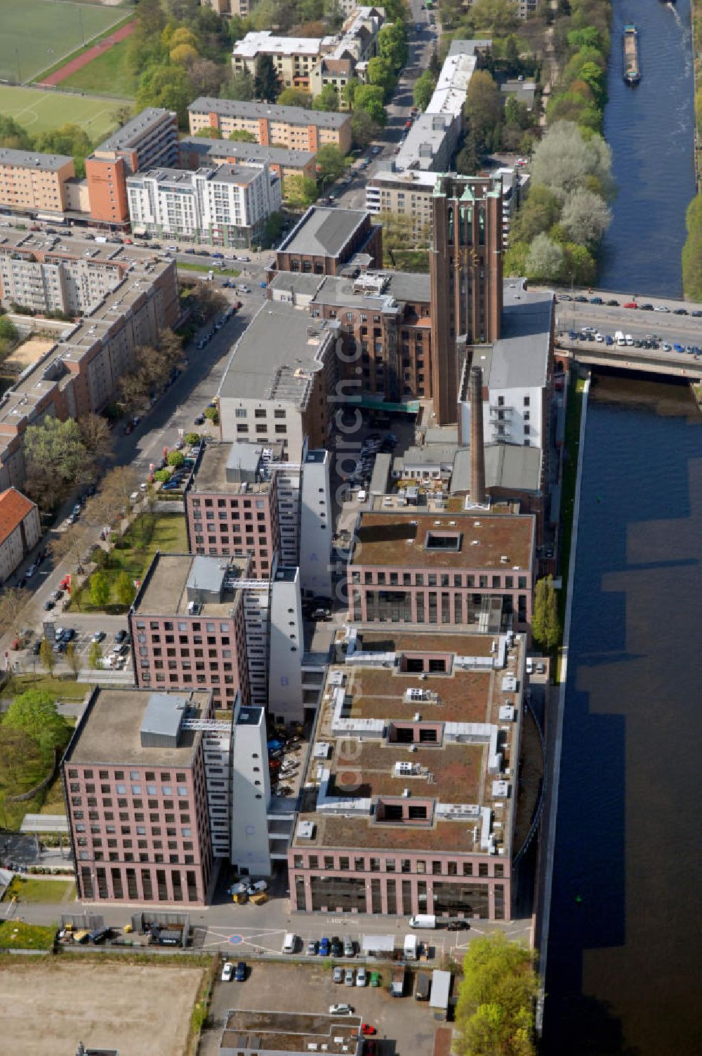 Aerial photograph Berlin - Geschäftshäuser und Ullsteinhaus am Teltowkanal im Bezirk Tempelhof-Schöneberg, Ortsteil Mariendorf. Das Ullsteinhaus wurde 1925-27 vom Architekten Prof. Eugen Schmol für den Ullstein-Verlag gebaut, der anschließend in dem Gebäude residierte. Heute beherbergt das Ullsteinhaus viele Geschäfte und Büros, dazu gehören u.a.: das Systemhaus Computacenter, die SCHUFA Holding AG, vers. medizinische Einrichtungen, die WBS Training AG Bildungspartner der SAP AG. Im Keller des Ullsteinhauses ist heute die Amber Suite zu finden. Commercials and the building Ullsteinhaus at the canal Teltowkanal in Berlin-Mariendorf.