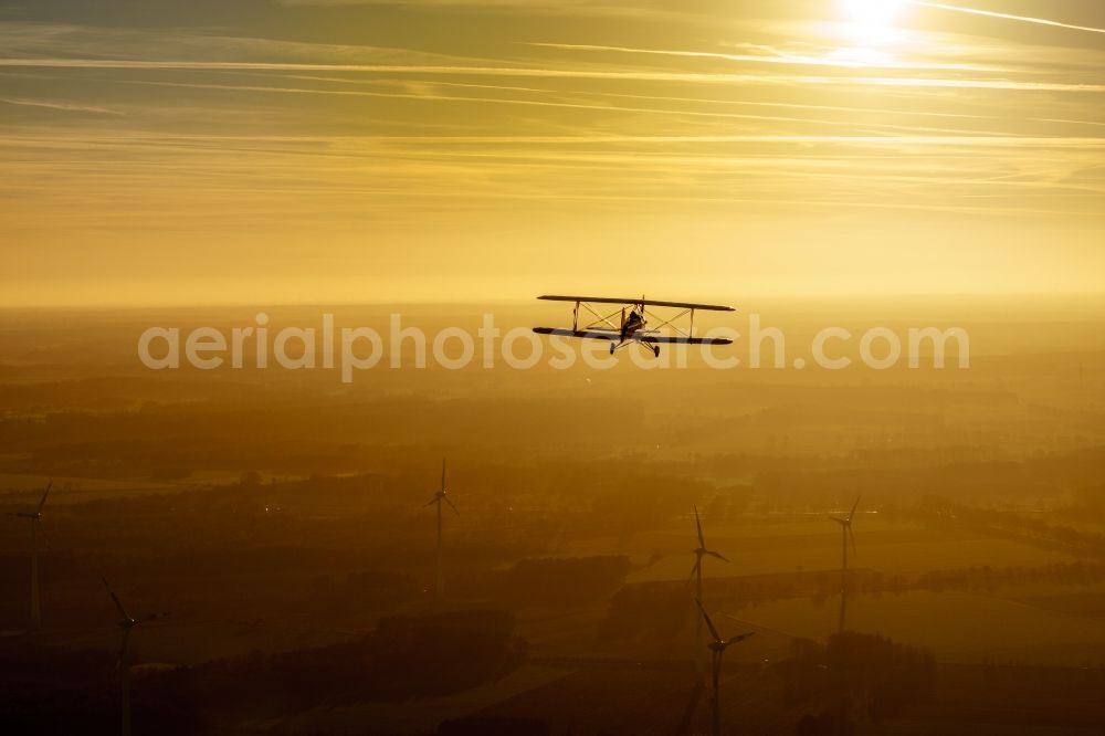 Oldendorf from the bird's eye view: Microlight aircraft Sunwheel D-MSLM while sunset over the lakes of moor near Oldendorf in Lower Saxony, Germany