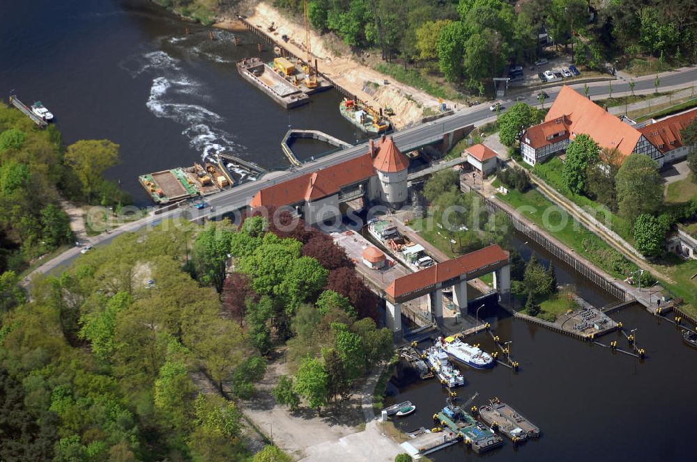 Kleinmachnow from the bird's eye view: Die Schleuse Kleinmachnow liegt im Teltowkanal und besteht aus 3 Schleusenkammern und einem Wehrdurchlass (Freiarche). Die zwei 67 m langen Schleusenkammern (im Bild links) wurden 1905 in Mauerwerksbauweise errichtet. 1940 wurde eine 3. Schleusenkammer in Spundwandbauweise erbaut, die Schiffe bis 85 m Länge schleusen kann. Die gesamte Anlage einschließlich Brücke und Schleusenstand steht unter Denkmalschutz. Im Rahmen des Verkehrsprojektes Deutsche Einheit Nr. 17 soll hier eine neue Schleuse gebaut werden, die von bis zu 185 m langen Schiffsverbänden passiert werden kann. Die Planung sieht eine 190 m lange Kammer in der vorhandenen Nordkammer vor.