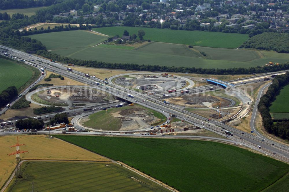 Aerial photograph KAMEN - Das Kamener Kreuz ist das zweiteälteste Autobahnkreuz in Kleeblattform Deutschlands und dient der Verbindung der ersten Autobahnen des Landes, der A 1 (Nord-Süd-Richtung) und der A 2 (Ost-West-Richtung). Seine Einweihung fand 1937 statt. Das Autobahnkreuz liegt im Nordosten des Ruhrgebiets bei Kamen und Bergkamen zwischen den Großstädten Dortmund und Hamm und ist auch aufgrund der hier aufeinan dertreffenden wichtigen Verkehrsachsen ein überaus stark befahrener Verkehrsknotenpunkt. Die meisten Autofahrer kennen das Kamener Kreuz über die Staumeldungen der Verkehrsrundfunksender. Das Kamener Kreuz wird täglich von 160.000 Fahrzeugen befahren. Zur Zeit wird das Kamener Kreuz ausgebaut. Die Fertigstellung soll Ende 2009 sein. Das Kreuz wird dann von allen Seiten sechsspurig zu befahren sein. Eine besondere Herausforderung hierbei ist der Abriss und komplette Neubau der A 1-Brücke, die täglich von 90.000 Fahrzeugen befahren wird. Das Kreuz wird dann seine klassische Kleeblattform verlieren, da der Verkehr von der A 2 aus Richtung Hannover über eine Rampe auf die A 1 in Richtung Köln geleitet wird. Ausführende Firmen sind OEVERMANN, Münster Verkehrswegebau und Schäfer