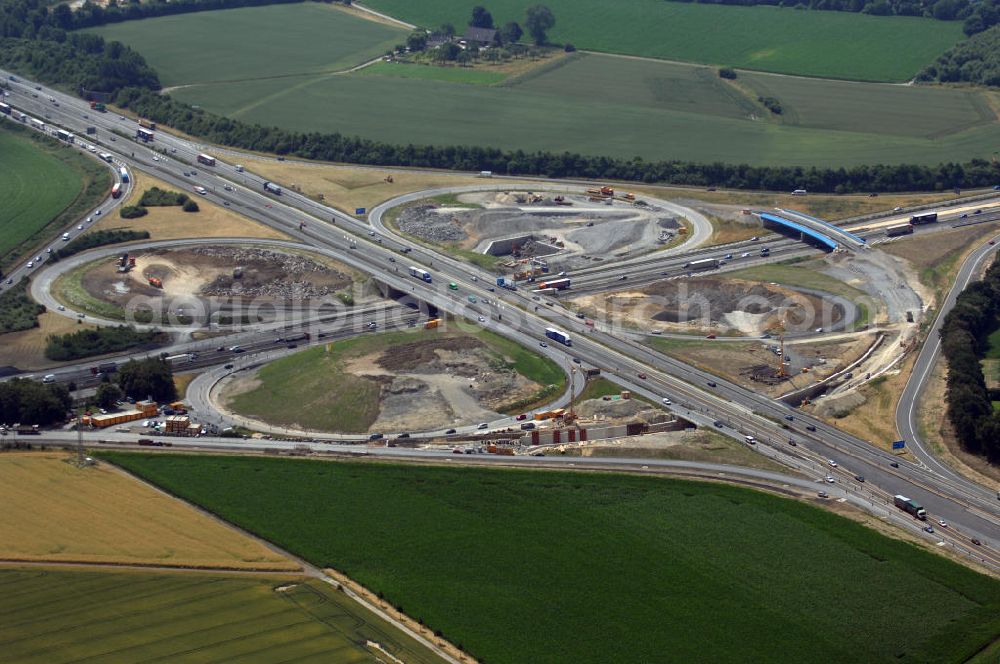 KAMEN from above - Das Kamener Kreuz ist das zweiteälteste Autobahnkreuz in Kleeblattform Deutschlands und dient der Verbindung der ersten Autobahnen des Landes, der A 1 (Nord-Süd-Richtung) und der A 2 (Ost-West-Richtung). Seine Einweihung fand 1937 statt. Das Autobahnkreuz liegt im Nordosten des Ruhrgebiets bei Kamen und Bergkamen zwischen den Großstädten Dortmund und Hamm und ist auch aufgrund der hier aufeinan dertreffenden wichtigen Verkehrsachsen ein überaus stark befahrener Verkehrsknotenpunkt. Die meisten Autofahrer kennen das Kamener Kreuz über die Staumeldungen der Verkehrsrundfunksender. Das Kamener Kreuz wird täglich von 160.000 Fahrzeugen befahren. Zur Zeit wird das Kamener Kreuz ausgebaut. Die Fertigstellung soll Ende 2009 sein. Das Kreuz wird dann von allen Seiten sechsspurig zu befahren sein. Eine besondere Herausforderung hierbei ist der Abriss und komplette Neubau der A 1-Brücke, die täglich von 90.000 Fahrzeugen befahren wird. Das Kreuz wird dann seine klassische Kleeblattform verlieren, da der Verkehr von der A 2 aus Richtung Hannover über eine Rampe auf die A 1 in Richtung Köln geleitet wird. Ausführende Firmen sind OEVERMANN, Münster Verkehrswegebau und Schäfer