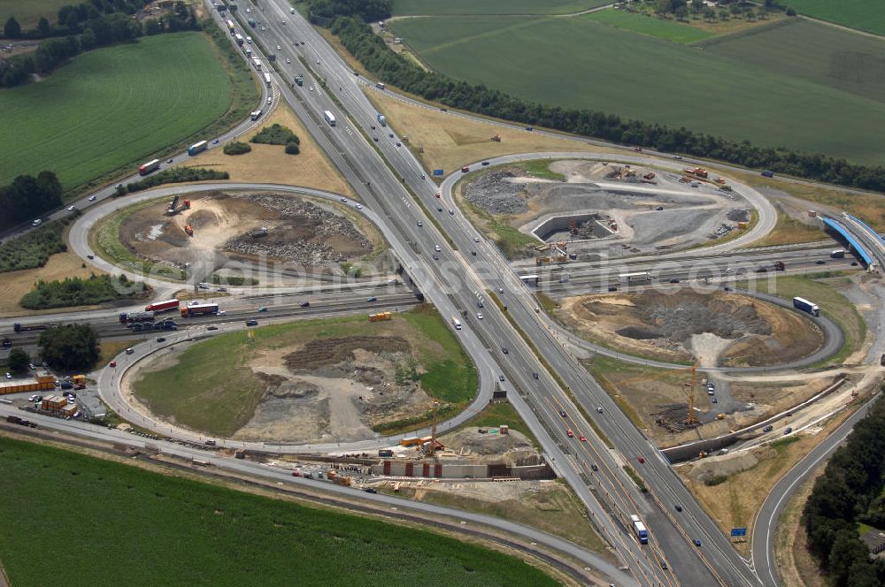 KAMEN from the bird's eye view: Das Kamener Kreuz ist das zweiteälteste Autobahnkreuz in Kleeblattform Deutschlands und dient der Verbindung der ersten Autobahnen des Landes, der A 1 (Nord-Süd-Richtung) und der A 2 (Ost-West-Richtung). Seine Einweihung fand 1937 statt. Das Autobahnkreuz liegt im Nordosten des Ruhrgebiets bei Kamen und Bergkamen zwischen den Großstädten Dortmund und Hamm und ist auch aufgrund der hier aufeinan dertreffenden wichtigen Verkehrsachsen ein überaus stark befahrener Verkehrsknotenpunkt. Die meisten Autofahrer kennen das Kamener Kreuz über die Staumeldungen der Verkehrsrundfunksender. Das Kamener Kreuz wird täglich von 160.000 Fahrzeugen befahren. Zur Zeit wird das Kamener Kreuz ausgebaut. Die Fertigstellung soll Ende 2009 sein. Das Kreuz wird dann von allen Seiten sechsspurig zu befahren sein. Eine besondere Herausforderung hierbei ist der Abriss und komplette Neubau der A 1-Brücke, die täglich von 90.000 Fahrzeugen befahren wird. Das Kreuz wird dann seine klassische Kleeblattform verlieren, da der Verkehr von der A 2 aus Richtung Hannover über eine Rampe auf die A 1 in Richtung Köln geleitet wird. Ausführende Firmen sind OEVERMANN, Münster Verkehrswegebau und Schäfer