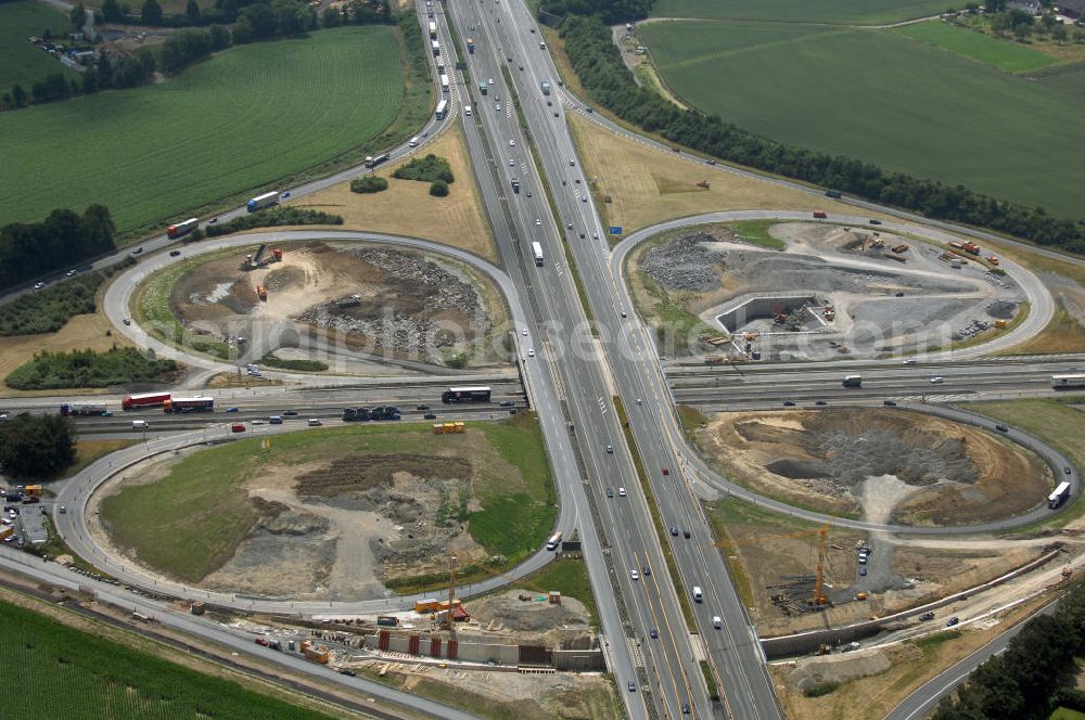 Aerial image KAMEN - Das Kamener Kreuz ist das zweiteälteste Autobahnkreuz in Kleeblattform Deutschlands und dient der Verbindung der ersten Autobahnen des Landes, der A 1 (Nord-Süd-Richtung) und der A 2 (Ost-West-Richtung). Seine Einweihung fand 1937 statt. Das Autobahnkreuz liegt im Nordosten des Ruhrgebiets bei Kamen und Bergkamen zwischen den Großstädten Dortmund und Hamm und ist auch aufgrund der hier aufeinan dertreffenden wichtigen Verkehrsachsen ein überaus stark befahrener Verkehrsknotenpunkt. Die meisten Autofahrer kennen das Kamener Kreuz über die Staumeldungen der Verkehrsrundfunksender. Das Kamener Kreuz wird täglich von 160.000 Fahrzeugen befahren. Zur Zeit wird das Kamener Kreuz ausgebaut. Die Fertigstellung soll Ende 2009 sein. Das Kreuz wird dann von allen Seiten sechsspurig zu befahren sein. Eine besondere Herausforderung hierbei ist der Abriss und komplette Neubau der A 1-Brücke, die täglich von 90.000 Fahrzeugen befahren wird. Das Kreuz wird dann seine klassische Kleeblattform verlieren, da der Verkehr von der A 2 aus Richtung Hannover über eine Rampe auf die A 1 in Richtung Köln geleitet wird. Ausführende Firmen sind OEVERMANN, Münster Verkehrswegebau und Schäfer