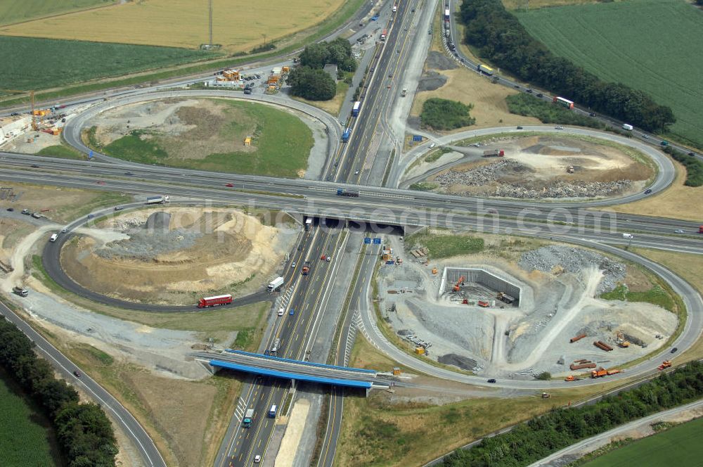 KAMEN from the bird's eye view: Das Kamener Kreuz ist das zweiteälteste Autobahnkreuz in Kleeblattform Deutschlands und dient der Verbindung der ersten Autobahnen des Landes, der A 1 (Nord-Süd-Richtung) und der A 2 (Ost-West-Richtung). Seine Einweihung fand 1937 statt. Das Autobahnkreuz liegt im Nordosten des Ruhrgebiets bei Kamen und Bergkamen zwischen den Großstädten Dortmund und Hamm und ist auch aufgrund der hier aufeinan dertreffenden wichtigen Verkehrsachsen ein überaus stark befahrener Verkehrsknotenpunkt. Die meisten Autofahrer kennen das Kamener Kreuz über die Staumeldungen der Verkehrsrundfunksender. Das Kamener Kreuz wird täglich von 160.000 Fahrzeugen befahren. Zur Zeit wird das Kamener Kreuz ausgebaut. Die Fertigstellung soll Ende 2009 sein. Das Kreuz wird dann von allen Seiten sechsspurig zu befahren sein. Eine besondere Herausforderung hierbei ist der Abriss und komplette Neubau der A 1-Brücke, die täglich von 90.000 Fahrzeugen befahren wird. Das Kreuz wird dann seine klassische Kleeblattform verlieren, da der Verkehr von der A 2 aus Richtung Hannover über eine Rampe auf die A 1 in Richtung Köln geleitet wird. Ausführende Firmen sind OEVERMANN, Münster Verkehrswegebau und Schäfer