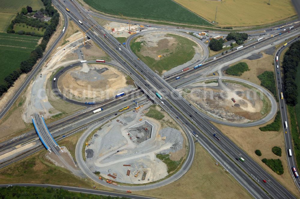 Aerial image KAMEN - Das Kamener Kreuz ist das zweiteälteste Autobahnkreuz in Kleeblattform Deutschlands und dient der Verbindung der ersten Autobahnen des Landes, der A 1 (Nord-Süd-Richtung) und der A 2 (Ost-West-Richtung). Seine Einweihung fand 1937 statt. Das Autobahnkreuz liegt im Nordosten des Ruhrgebiets bei Kamen und Bergkamen zwischen den Großstädten Dortmund und Hamm und ist auch aufgrund der hier aufeinan dertreffenden wichtigen Verkehrsachsen ein überaus stark befahrener Verkehrsknotenpunkt. Die meisten Autofahrer kennen das Kamener Kreuz über die Staumeldungen der Verkehrsrundfunksender. Das Kamener Kreuz wird täglich von 160.000 Fahrzeugen befahren. Zur Zeit wird das Kamener Kreuz ausgebaut. Die Fertigstellung soll Ende 2009 sein. Das Kreuz wird dann von allen Seiten sechsspurig zu befahren sein. Eine besondere Herausforderung hierbei ist der Abriss und komplette Neubau der A 1-Brücke, die täglich von 90.000 Fahrzeugen befahren wird. Das Kreuz wird dann seine klassische Kleeblattform verlieren, da der Verkehr von der A 2 aus Richtung Hannover über eine Rampe auf die A 1 in Richtung Köln geleitet wird. Ausführende Firmen sind OEVERMANN, Münster Verkehrswegebau und Schäfer