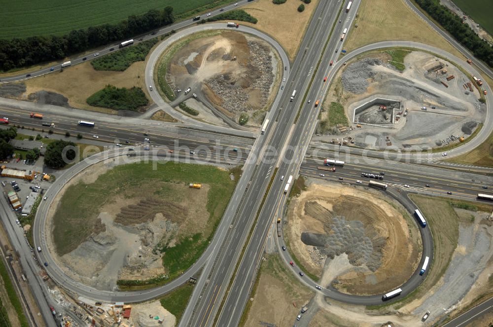 Aerial photograph KAMEN - Das Kamener Kreuz ist das zweiteälteste Autobahnkreuz in Kleeblattform Deutschlands und dient der Verbindung der ersten Autobahnen des Landes, der A 1 (Nord-Süd-Richtung) und der A 2 (Ost-West-Richtung). Seine Einweihung fand 1937 statt. Das Autobahnkreuz liegt im Nordosten des Ruhrgebiets bei Kamen und Bergkamen zwischen den Großstädten Dortmund und Hamm und ist auch aufgrund der hier aufeinan dertreffenden wichtigen Verkehrsachsen ein überaus stark befahrener Verkehrsknotenpunkt. Die meisten Autofahrer kennen das Kamener Kreuz über die Staumeldungen der Verkehrsrundfunksender. Das Kamener Kreuz wird täglich von 160.000 Fahrzeugen befahren. Zur Zeit wird das Kamener Kreuz ausgebaut. Die Fertigstellung soll Ende 2009 sein. Das Kreuz wird dann von allen Seiten sechsspurig zu befahren sein. Eine besondere Herausforderung hierbei ist der Abriss und komplette Neubau der A 1-Brücke, die täglich von 90.000 Fahrzeugen befahren wird. Das Kreuz wird dann seine klassische Kleeblattform verlieren, da der Verkehr von der A 2 aus Richtung Hannover über eine Rampe auf die A 1 in Richtung Köln geleitet wird. Ausführende Firmen sind OEVERMANN, Münster Verkehrswegebau und Schäfer