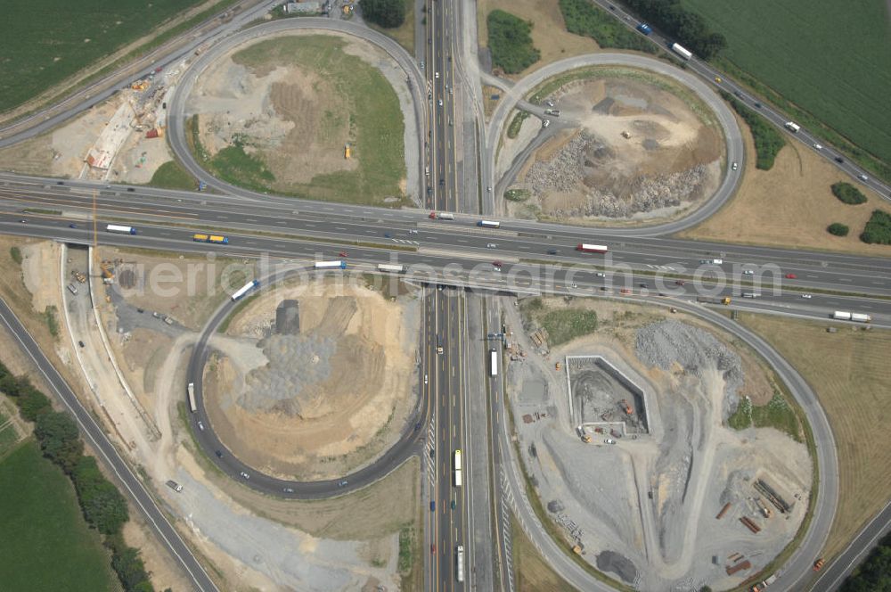 KAMEN from above - Das Kamener Kreuz ist das zweiteälteste Autobahnkreuz in Kleeblattform Deutschlands und dient der Verbindung der ersten Autobahnen des Landes, der A 1 (Nord-Süd-Richtung) und der A 2 (Ost-West-Richtung). Seine Einweihung fand 1937 statt. Das Autobahnkreuz liegt im Nordosten des Ruhrgebiets bei Kamen und Bergkamen zwischen den Großstädten Dortmund und Hamm und ist auch aufgrund der hier aufeinan dertreffenden wichtigen Verkehrsachsen ein überaus stark befahrener Verkehrsknotenpunkt. Die meisten Autofahrer kennen das Kamener Kreuz über die Staumeldungen der Verkehrsrundfunksender. Das Kamener Kreuz wird täglich von 160.000 Fahrzeugen befahren. Zur Zeit wird das Kamener Kreuz ausgebaut. Die Fertigstellung soll Ende 2009 sein. Das Kreuz wird dann von allen Seiten sechsspurig zu befahren sein. Eine besondere Herausforderung hierbei ist der Abriss und komplette Neubau der A 1-Brücke, die täglich von 90.000 Fahrzeugen befahren wird. Das Kreuz wird dann seine klassische Kleeblattform verlieren, da der Verkehr von der A 2 aus Richtung Hannover über eine Rampe auf die A 1 in Richtung Köln geleitet wird. Ausführende Firmen sind OEVERMANN, Münster Verkehrswegebau und Schäfer