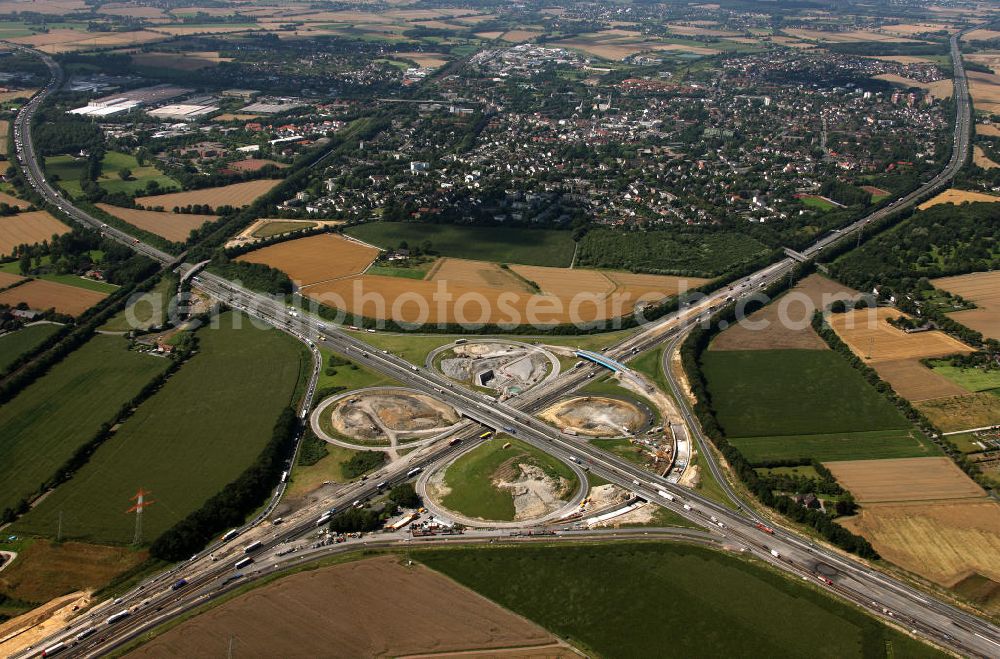 Kamen from the bird's eye view: Das Kamener Kreuz ist das zweiteälteste Autobahnkreuz in Kleeblattform Deutschlands und dient der Verbindung der ersten Autobahnen des Landes, der A 1 (Nord-Süd-Richtung) und der A 2 (Ost-West-Richtung). Seine Einweihung fand 1937 statt. Das Autobahnkreuz liegt im Nordosten des Ruhrgebiets bei Kamen und Bergkamen zwischen den Großstädten Dortmund und Hamm und ist auch aufgrund der hier aufeinan dertreffenden wichtigen Verkehrsachsen ein überaus stark befahrener Verkehrsknotenpunkt. Die meisten Autofahrer kennen das Kamener Kreuz über die Staumeldungen der Verkehrsrundfunksender. Das Kamener Kreuz wird täglich von 160.000 Fahrzeugen befahren. Zur Zeit wird das Kamener Kreuz ausgebaut. Die Fertigstellung soll Ende 2009 sein. Das Kreuz wird dann von allen Seiten sechsspurig zu befahren sein. Eine besondere Herausforderung hierbei ist der Abriss und komplette Neubau der A 1-Brücke, die täglich von 90.000 Fahrzeugen befahren wird. Das Kreuz wird dann seine klassische Kleeblattform verlieren, da der Verkehr von der A 2 aus Richtung Hannover über eine Rampe auf die A 1 in Richtung Köln geleitet wird. Ausführende Firmen sind OEVERMANN, Münster Verkehrswegebau und Schäfer