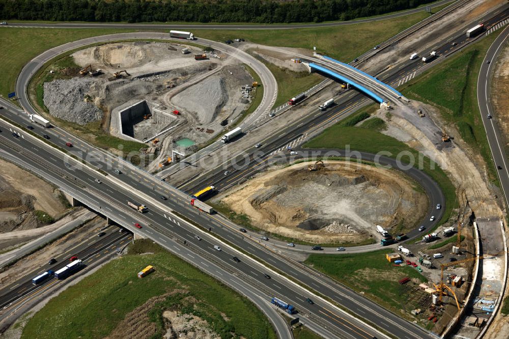 Aerial photograph Kamen - Das Kamener Kreuz ist das zweiteälteste Autobahnkreuz in Kleeblattform Deutschlands und dient der Verbindung der ersten Autobahnen des Landes, der A 1 (Nord-Süd-Richtung) und der A 2 (Ost-West-Richtung). Seine Einweihung fand 1937 statt. Das Autobahnkreuz liegt im Nordosten des Ruhrgebiets bei Kamen und Bergkamen zwischen den Großstädten Dortmund und Hamm und ist auch aufgrund der hier aufeinan dertreffenden wichtigen Verkehrsachsen ein überaus stark befahrener Verkehrsknotenpunkt. Die meisten Autofahrer kennen das Kamener Kreuz über die Staumeldungen der Verkehrsrundfunksender. Das Kamener Kreuz wird täglich von 160.000 Fahrzeugen befahren. Zur Zeit wird das Kamener Kreuz ausgebaut. Die Fertigstellung soll Ende 2009 sein. Das Kreuz wird dann von allen Seiten sechsspurig zu befahren sein. Eine besondere Herausforderung hierbei ist der Abriss und komplette Neubau der A 1-Brücke, die täglich von 90.000 Fahrzeugen befahren wird. Das Kreuz wird dann seine klassische Kleeblattform verlieren, da der Verkehr von der A 2 aus Richtung Hannover über eine Rampe auf die A 1 in Richtung Köln geleitet wird. Ausführende Firmen sind OEVERMANN, Münster Verkehrswegebau und Schäfer