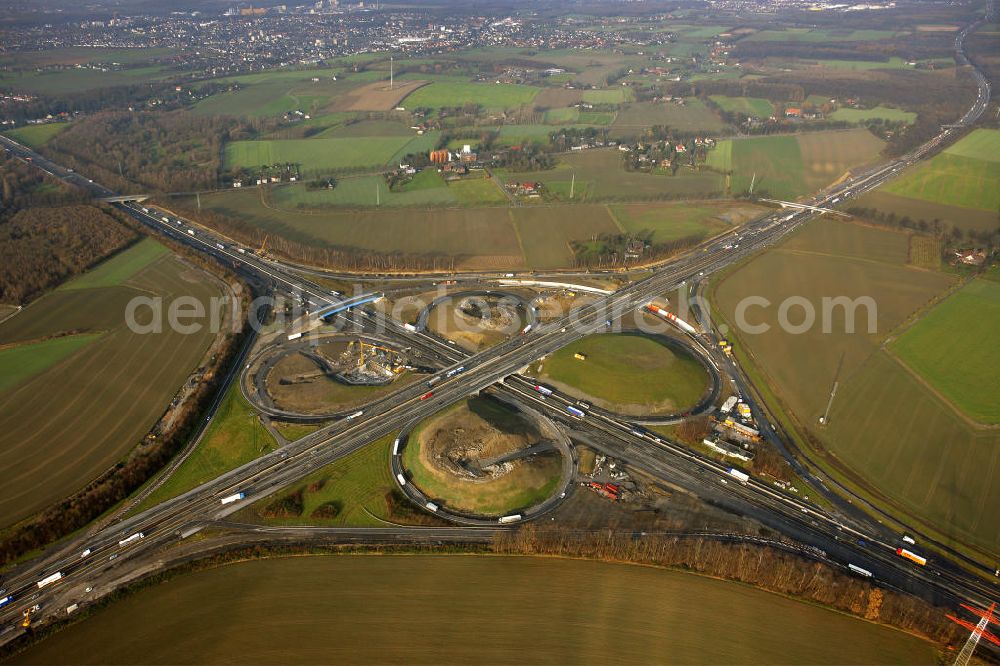 Kamen from the bird's eye view: Das Kamener Kreuz ist das zweiteälteste Autobahnkreuz in Kleeblattform Deutschlands und dient der Verbindung der ersten Autobahnen des Landes, der A 1 (Nord-Süd-Richtung) und der A 2 (Ost-West-Richtung). Seine Einweihung fand 1937 statt. Das Autobahnkreuz liegt im Nordosten des Ruhrgebiets bei Kamen und Bergkamen zwischen den Großstädten Dortmund und Hamm und ist auch aufgrund der hier aufeinan dertreffenden wichtigen Verkehrsachsen ein überaus stark befahrener Verkehrsknotenpunkt. Die meisten Autofahrer kennen das Kamener Kreuz über die Staumeldungen der Verkehrsrundfunksender. Das Kamener Kreuz wird täglich von 160.000 Fahrzeugen befahren. Zur Zeit wird das Kamener Kreuz ausgebaut. Die Fertigstellung soll Ende 2009 sein. Das Kreuz wird dann von allen Seiten sechsspurig zu befahren sein. Eine besondere Herausforderung hierbei ist der Abriss und komplette Neubau der A 1-Brücke, die täglich von 90.000 Fahrzeugen befahren wird. Das Kreuz wird dann seine klassische Kleeblattform verlieren, da der Verkehr von der A 2 aus Richtung Hannover über eine Rampe auf die A 1 in Richtung Köln geleitet wird. Ausführende Firmen sind OEVERMANN, Münster Verkehrswegebau und Schäfer