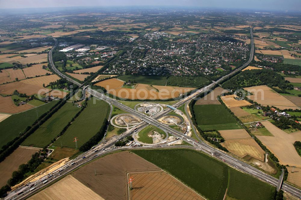 Kamen from the bird's eye view: Das Kamener Kreuz ist das zweiteälteste Autobahnkreuz in Kleeblattform Deutschlands und dient der Verbindung der ersten Autobahnen des Landes, der A 1 (Nord-Süd-Richtung) und der A 2 (Ost-West-Richtung). Seine Einweihung fand 1937 statt. Das Autobahnkreuz liegt im Nordosten des Ruhrgebiets bei Kamen und Bergkamen zwischen den Großstädten Dortmund und Hamm und ist auch aufgrund der hier aufeinan dertreffenden wichtigen Verkehrsachsen ein überaus stark befahrener Verkehrsknotenpunkt. Die meisten Autofahrer kennen das Kamener Kreuz über die Staumeldungen der Verkehrsrundfunksender. Das Kamener Kreuz wird täglich von 160.000 Fahrzeugen befahren. Zur Zeit wird das Kamener Kreuz ausgebaut. Die Fertigstellung soll Ende 2009 sein. Das Kreuz wird dann von allen Seiten sechsspurig zu befahren sein. Eine besondere Herausforderung hierbei ist der Abriss und komplette Neubau der A 1-Brücke, die täglich von 90.000 Fahrzeugen befahren wird. Das Kreuz wird dann seine klassische Kleeblattform verlieren, da der Verkehr von der A 2 aus Richtung Hannover über eine Rampe auf die A 1 in Richtung Köln geleitet wird. Ausführende Firmen sind OEVERMANN, Münster Verkehrswegebau und Schäfer