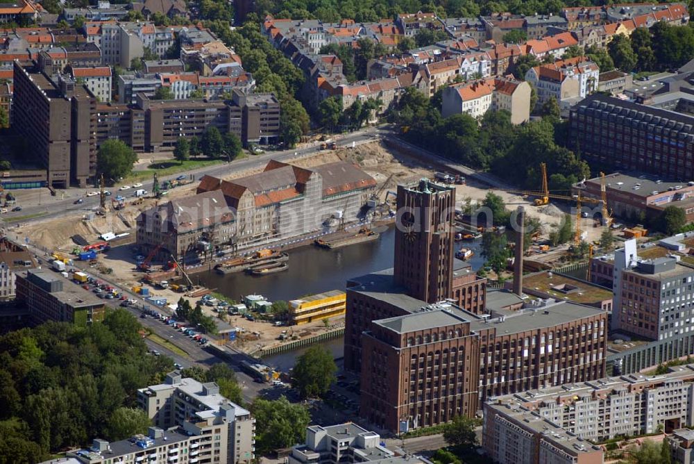 Aerial image Berlin - Blick auf die Umbauarbeiten am Tempelhofer Hafen, der zuletzt nur noch als Schrott- und Lagerplatz diente. Das 100-Millionen-Euro-Neubauprojekt soll die städtebauliche Lücke am Südende des Tempelhofer Damms schließen. Die Grundstücksgesellschaft Objekt Tempelhofer Hafen, ein Joint Venture der HLG Münster/Berlin und der IKB Deutsche Industriebank gestaltet das Areal zwischen Ordensmeisterstraße und Teltowkanal auf einer Fläche von 45 000 Quadratmetern, davon 15 000 Quadratmeter Wasserfläche. Neben dem historischen Speicher, der aufwendig saniert werden soll, werden vier Gebäude entstehen, die das Hafenbecken an drei Seiten umrahmen werden. Entlang der Ordensmeisterstraße entsteht eine viergeschossige Shopping-Meile mit 70 Geschäften und 600 Stellplätzen im angeschlossenen Parkhaus. Die Verkaufsfläche beträgt 19 500 Quadratmeter, Ankermieter sind C&A, H&M, Marktkauf und ein Elektronikmarkt, so HLG-Geschäftsführer Christian Diesen.