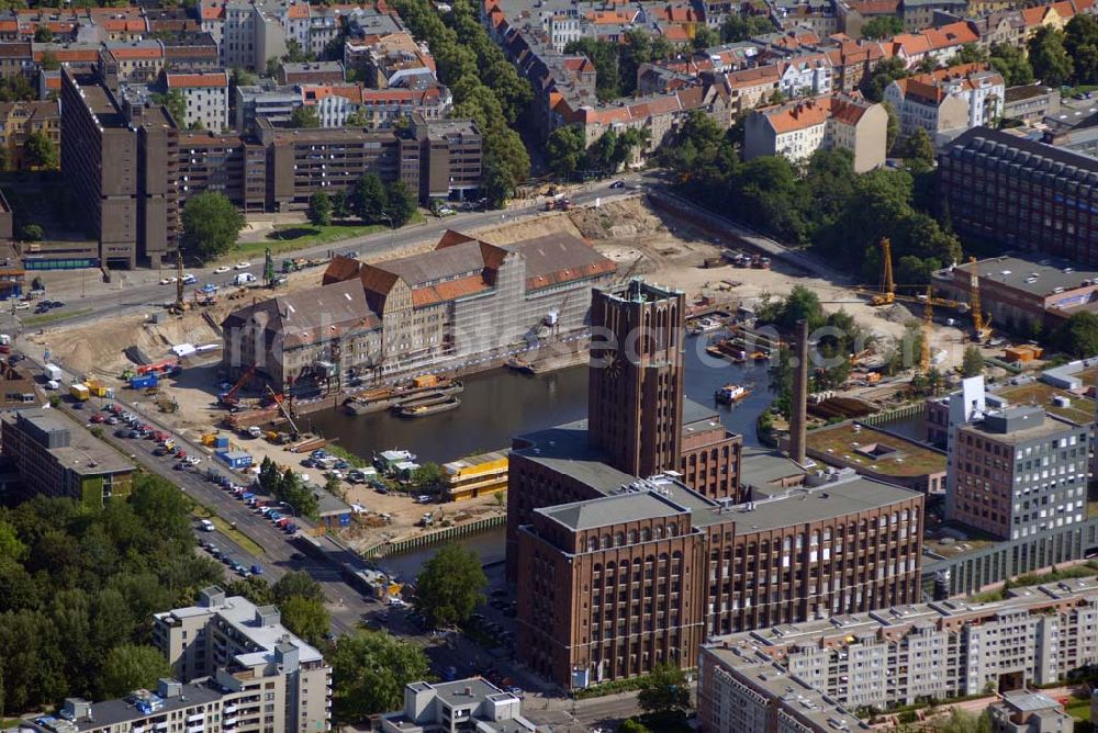 Aerial photograph Berlin - Blick auf die Umbauarbeiten am Tempelhofer Hafen, der zuletzt nur noch als Schrott- und Lagerplatz diente. Das 100-Millionen-Euro-Neubauprojekt soll die städtebauliche Lücke am Südende des Tempelhofer Damms schließen. Die Grundstücksgesellschaft Objekt Tempelhofer Hafen, ein Joint Venture der HLG Münster/Berlin und der IKB Deutsche Industriebank gestaltet das Areal zwischen Ordensmeisterstraße und Teltowkanal auf einer Fläche von 45 000 Quadratmetern, davon 15 000 Quadratmeter Wasserfläche. Neben dem historischen Speicher, der aufwendig saniert werden soll, werden vier Gebäude entstehen, die das Hafenbecken an drei Seiten umrahmen werden. Entlang der Ordensmeisterstraße entsteht eine viergeschossige Shopping-Meile mit 70 Geschäften und 600 Stellplätzen im angeschlossenen Parkhaus. Die Verkaufsfläche beträgt 19 500 Quadratmeter, Ankermieter sind C&A, H&M, Marktkauf und ein Elektronikmarkt, so HLG-Geschäftsführer Christian Diesen.