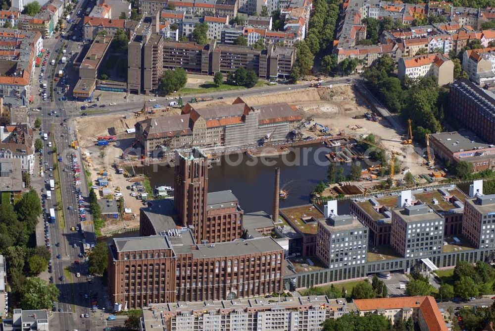 Berlin from the bird's eye view: Blick auf die Umbauarbeiten am Tempelhofer Hafen, der zuletzt nur noch als Schrott- und Lagerplatz diente. Das 100-Millionen-Euro-Neubauprojekt soll die städtebauliche Lücke am Südende des Tempelhofer Damms schließen. Die Grundstücksgesellschaft Objekt Tempelhofer Hafen, ein Joint Venture der HLG Münster/Berlin und der IKB Deutsche Industriebank gestaltet das Areal zwischen Ordensmeisterstraße und Teltowkanal auf einer Fläche von 45 000 Quadratmetern, davon 15 000 Quadratmeter Wasserfläche. Neben dem historischen Speicher, der aufwendig saniert werden soll, werden vier Gebäude entstehen, die das Hafenbecken an drei Seiten umrahmen werden. Entlang der Ordensmeisterstraße entsteht eine viergeschossige Shopping-Meile mit 70 Geschäften und 600 Stellplätzen im angeschlossenen Parkhaus. Die Verkaufsfläche beträgt 19 500 Quadratmeter, Ankermieter sind C&A, H&M, Marktkauf und ein Elektronikmarkt, so HLG-Geschäftsführer Christian Diesen.