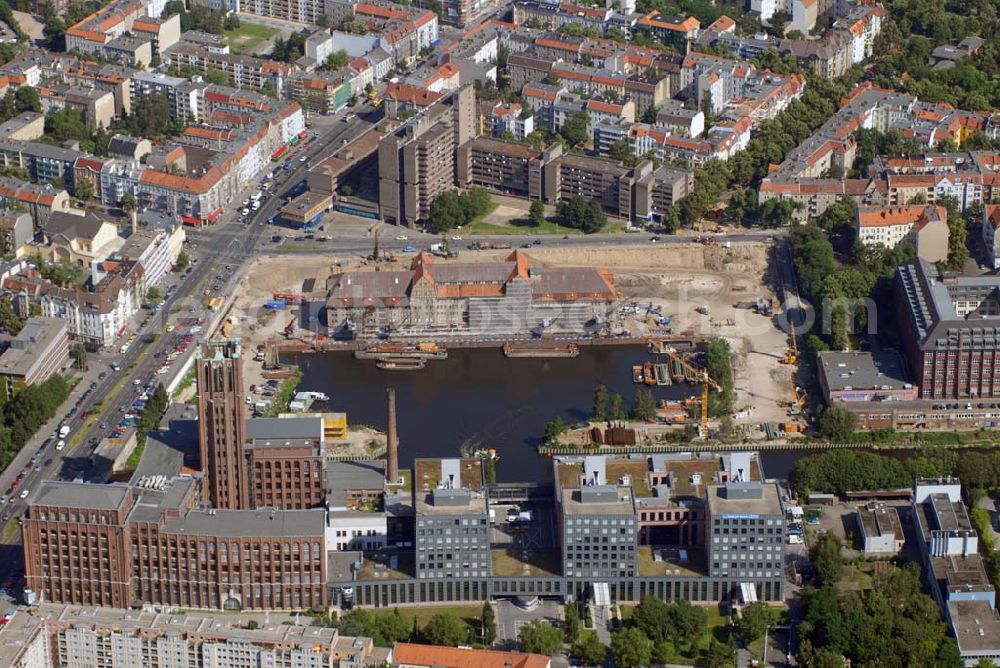 Aerial image Berlin - Blick auf die Umbauarbeiten am Tempelhofer Hafen, der zuletzt nur noch als Schrott- und Lagerplatz diente. Das 100-Millionen-Euro-Neubauprojekt soll die städtebauliche Lücke am Südende des Tempelhofer Damms schließen. Die Grundstücksgesellschaft Objekt Tempelhofer Hafen, ein Joint Venture der HLG Münster/Berlin und der IKB Deutsche Industriebank gestaltet das Areal zwischen Ordensmeisterstraße und Teltowkanal auf einer Fläche von 45 000 Quadratmetern, davon 15 000 Quadratmeter Wasserfläche. Neben dem historischen Speicher, der aufwendig saniert werden soll, werden vier Gebäude entstehen, die das Hafenbecken an drei Seiten umrahmen werden. Entlang der Ordensmeisterstraße entsteht eine viergeschossige Shopping-Meile mit 70 Geschäften und 600 Stellplätzen im angeschlossenen Parkhaus. Die Verkaufsfläche beträgt 19 500 Quadratmeter, Ankermieter sind C&A, H&M, Marktkauf und ein Elektronikmarkt, so HLG-Geschäftsführer Christian Diesen.