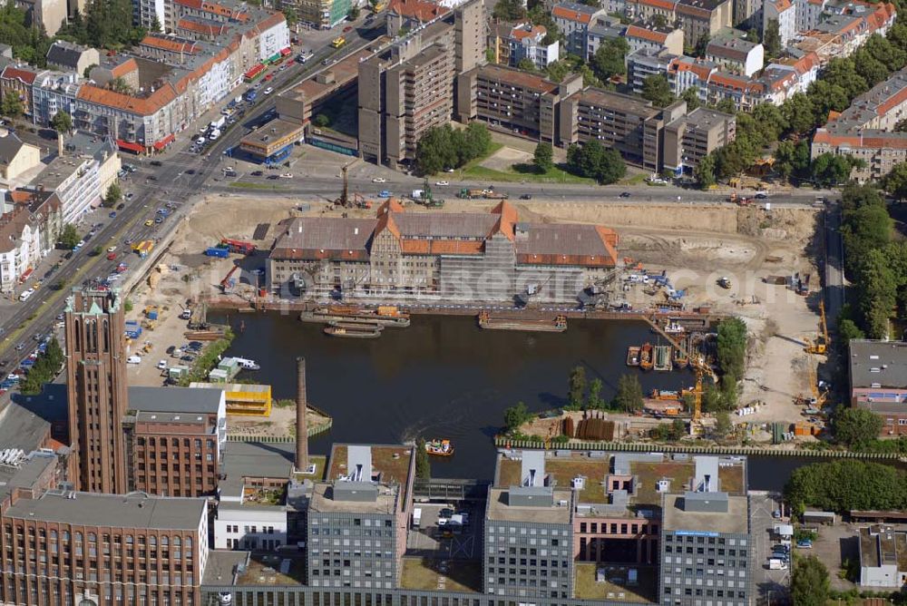 Aerial photograph Berlin - Blick auf die Umbauarbeiten am Tempelhofer Hafen, der zuletzt nur noch als Schrott- und Lagerplatz diente. Das 100-Millionen-Euro-Neubauprojekt soll die städtebauliche Lücke am Südende des Tempelhofer Damms schließen. Die Grundstücksgesellschaft Objekt Tempelhofer Hafen, ein Joint Venture der HLG Münster/Berlin und der IKB Deutsche Industriebank gestaltet das Areal zwischen Ordensmeisterstraße und Teltowkanal auf einer Fläche von 45 000 Quadratmetern, davon 15 000 Quadratmeter Wasserfläche. Neben dem historischen Speicher, der aufwendig saniert werden soll, werden vier Gebäude entstehen, die das Hafenbecken an drei Seiten umrahmen werden. Entlang der Ordensmeisterstraße entsteht eine viergeschossige Shopping-Meile mit 70 Geschäften und 600 Stellplätzen im angeschlossenen Parkhaus. Die Verkaufsfläche beträgt 19 500 Quadratmeter, Ankermieter sind C&A, H&M, Marktkauf und ein Elektronikmarkt, so HLG-Geschäftsführer Christian Diesen.