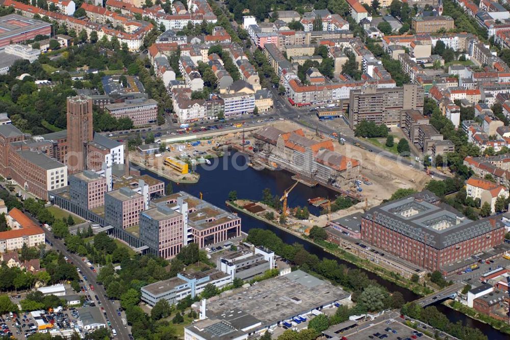 Berlin from the bird's eye view: Blick auf die Umbauarbeiten am Tempelhofer Hafen, der zuletzt nur noch als Schrott- und Lagerplatz diente. Das 100-Millionen-Euro-Neubauprojekt soll die städtebauliche Lücke am Südende des Tempelhofer Damms schließen. Die Grundstücksgesellschaft Objekt Tempelhofer Hafen, ein Joint Venture der HLG Münster/Berlin und der IKB Deutsche Industriebank gestaltet das Areal zwischen Ordensmeisterstraße und Teltowkanal auf einer Fläche von 45 000 Quadratmetern, davon 15 000 Quadratmeter Wasserfläche. Neben dem historischen Speicher, der aufwendig saniert werden soll, werden vier Gebäude entstehen, die das Hafenbecken an drei Seiten umrahmen werden. Entlang der Ordensmeisterstraße entsteht eine viergeschossige Shopping-Meile mit 70 Geschäften und 600 Stellplätzen im angeschlossenen Parkhaus. Die Verkaufsfläche beträgt 19 500 Quadratmeter, Ankermieter sind C&A, H&M, Marktkauf und ein Elektronikmarkt, so HLG-Geschäftsführer Christian Diesen.