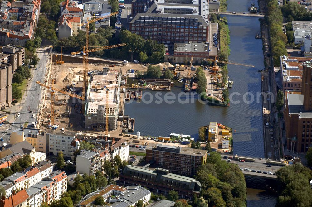 Aerial image Berlin - Blick auf die Umbauarbeiten am Tempelhofer Hafen, der zuletzt nur noch als Schrott- und Lagerplatz diente. Das 100-Millionen-Euro-Neubauprojekt soll die städtebauliche Lücke am Südende des Tempelhofer Damms schließen. Die Grundstücksgesellschaft Objekt Tempelhofer Hafen, ein Joint Venture der HLG Münster/Berlin und der IKB Deutsche Industriebank gestaltet das Areal zwischen Ordensmeisterstraße und Teltowkanal auf einer Fläche von 45 000 Quadratmetern, davon 15 000 Quadratmeter Wasserfläche. Neben dem historischen Speicher, der aufwendig saniert werden soll, werden vier Gebäude entstehen, die das Hafenbecken an drei Seiten umrahmen werden. Entlang der Ordensmeisterstraße entsteht eine viergeschossige Shopping-Meile mit 70 Geschäften und 600 Stellplätzen im angeschlossenen Parkhaus. Die Verkaufsfläche beträgt 19 500 Quadratmeter, Ankermieter sind C&A, H&M, Marktkauf und ein Elektronikmarkt, so HLG-Geschäftsführer Christian Diesen.