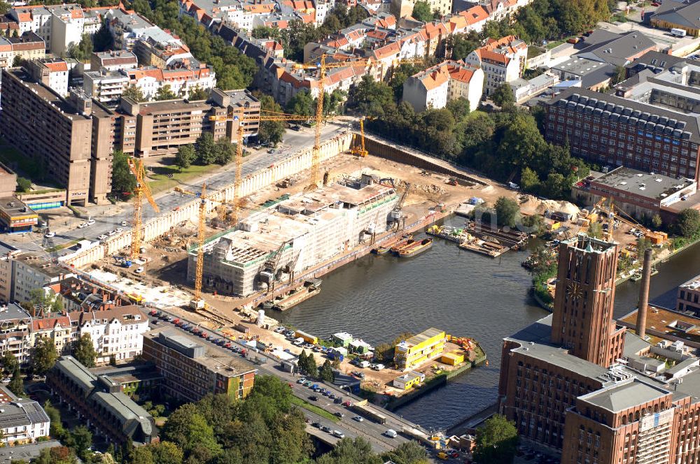 Aerial photograph Berlin - Blick auf die Umbauarbeiten am Tempelhofer Hafen, der zuletzt nur noch als Schrott- und Lagerplatz diente. Das 100-Millionen-Euro-Neubauprojekt soll die städtebauliche Lücke am Südende des Tempelhofer Damms schließen. Die Grundstücksgesellschaft Objekt Tempelhofer Hafen, ein Joint Venture der HLG Münster/Berlin und der IKB Deutsche Industriebank gestaltet das Areal zwischen Ordensmeisterstraße und Teltowkanal auf einer Fläche von 45 000 Quadratmetern, davon 15 000 Quadratmeter Wasserfläche. Neben dem historischen Speicher, der aufwendig saniert werden soll, werden vier Gebäude entstehen, die das Hafenbecken an drei Seiten umrahmen werden. Entlang der Ordensmeisterstraße entsteht eine viergeschossige Shopping-Meile mit 70 Geschäften und 600 Stellplätzen im angeschlossenen Parkhaus. Die Verkaufsfläche beträgt 19 500 Quadratmeter, Ankermieter sind C&A, H&M, Marktkauf und ein Elektronikmarkt, so HLG-Geschäftsführer Christian Diesen.