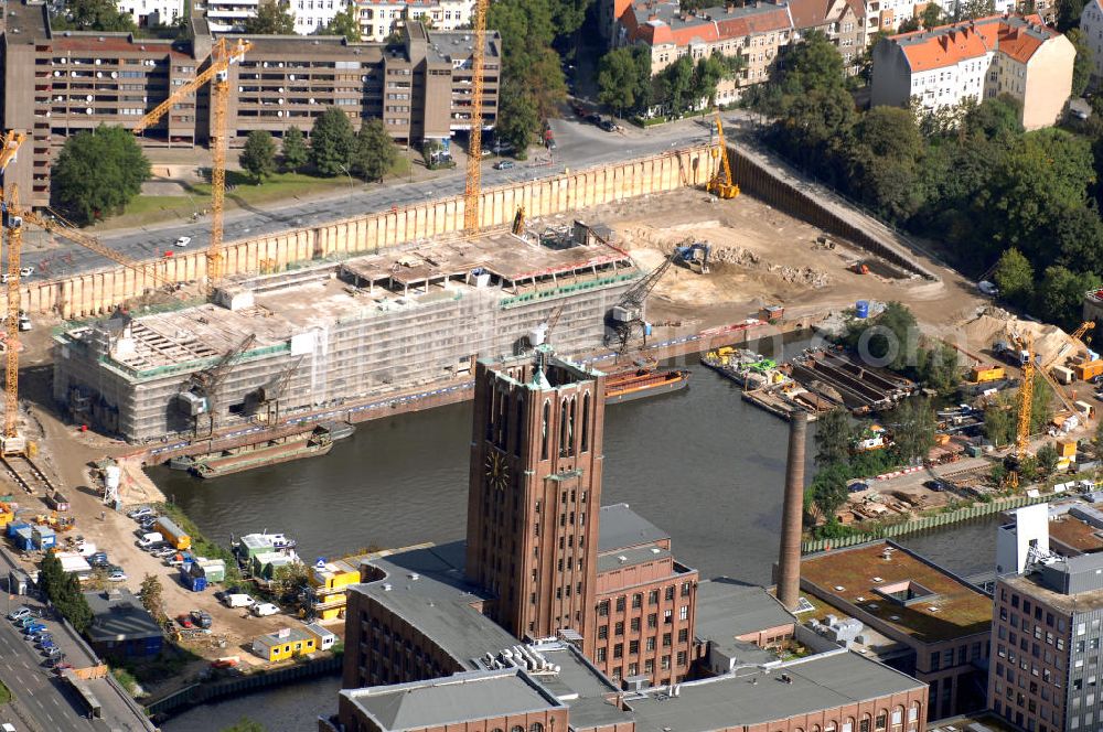 Aerial photograph Berlin - Blick auf die Umbauarbeiten am Tempelhofer Hafen, der zuletzt nur noch als Schrott- und Lagerplatz diente. Das 100-Millionen-Euro-Neubauprojekt soll die städtebauliche Lücke am Südende des Tempelhofer Damms schließen. Die Grundstücksgesellschaft Objekt Tempelhofer Hafen, ein Joint Venture der HLG Münster/Berlin und der IKB Deutsche Industriebank gestaltet das Areal zwischen Ordensmeisterstraße und Teltowkanal auf einer Fläche von 45 000 Quadratmetern, davon 15 000 Quadratmeter Wasserfläche. Neben dem historischen Speicher, der aufwendig saniert werden soll, werden vier Gebäude entstehen, die das Hafenbecken an drei Seiten umrahmen werden. Entlang der Ordensmeisterstraße entsteht eine viergeschossige Shopping-Meile mit 70 Geschäften und 600 Stellplätzen im angeschlossenen Parkhaus. Die Verkaufsfläche beträgt 19 500 Quadratmeter, Ankermieter sind C&A, H&M, Marktkauf und ein Elektronikmarkt, so HLG-Geschäftsführer Christian Diesen.