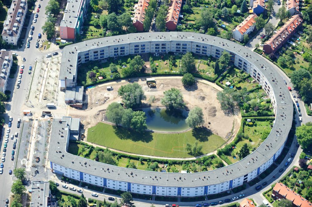 Aerial photograph Berlin Britz - Blick auf die Hufeisensiedlung in Britz. Derzeit laufen umfangreiche Grünflächenumgestaltungsarbeiten rund um den Hufeisenteich an der Mittelinsel Hüsung. Das Landesdenkmalamt verfolgt mit der umstrittenen Umgestaltung das Ziel, das ursprüngliche Erscheinungsbild von 1930 nach den Plänen der Architekten Taut/Wagner wieder herzustellen. Das Wohngebiet Hufeisensiedlung ist 2008 als Siedlung der Berliner Moderne von der UNESCO in die Liste des Welterbes aufgenommen worden. Die Großsiedlung Britz, nach der zentralen Baugruppe Hufeisensiedlung genannt, entstand 1925 -33 (in sieben Bauabschnitten) nach Plänen von Bruno Taut. The residential area Hufeisensiedlung in Berlin Britz.