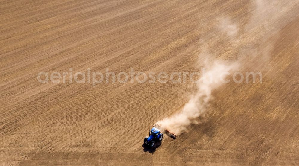 Grimma from above - Plowing and shifting the earth by a tractor with plow on agricultural fields in Grimma in the state Saxony, Germany