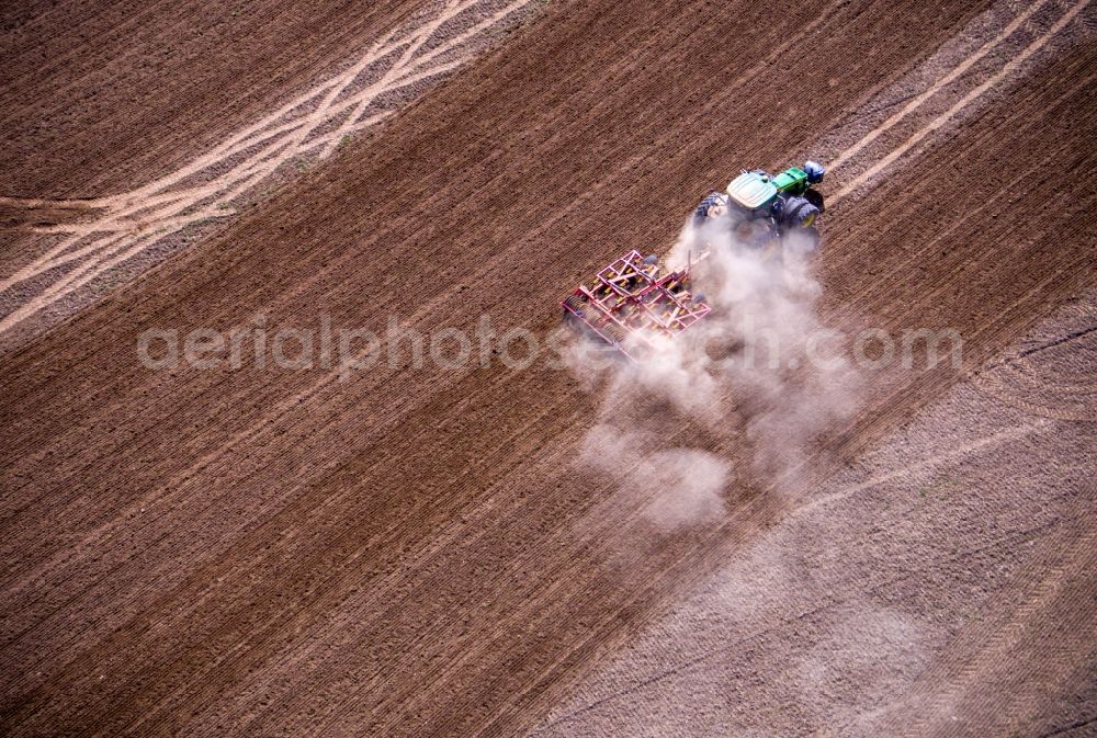 Aerial image Jürgenshagen - Plowing and shifting the earth by a tractor with plow on agricultural fields in Juergenshagen in the state Mecklenburg - Western Pomerania, Germany