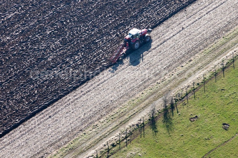 Aerial photograph Lampertsloch - Plowing and shifting the earth by a tractor with plow on agricultural fields in Lampertsloch in Alsace-Champagne-Ardenne-Lorraine, France